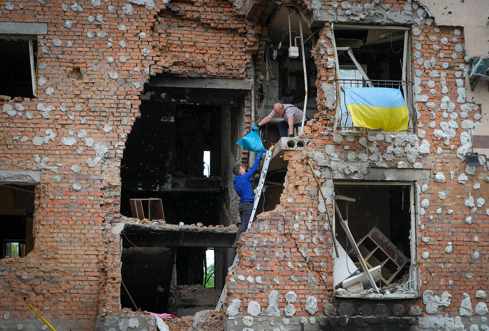 Residents take out their belongings from their house ruined by the Russian shelling in Irpin, Ukraine, on Saturday, May 21.
