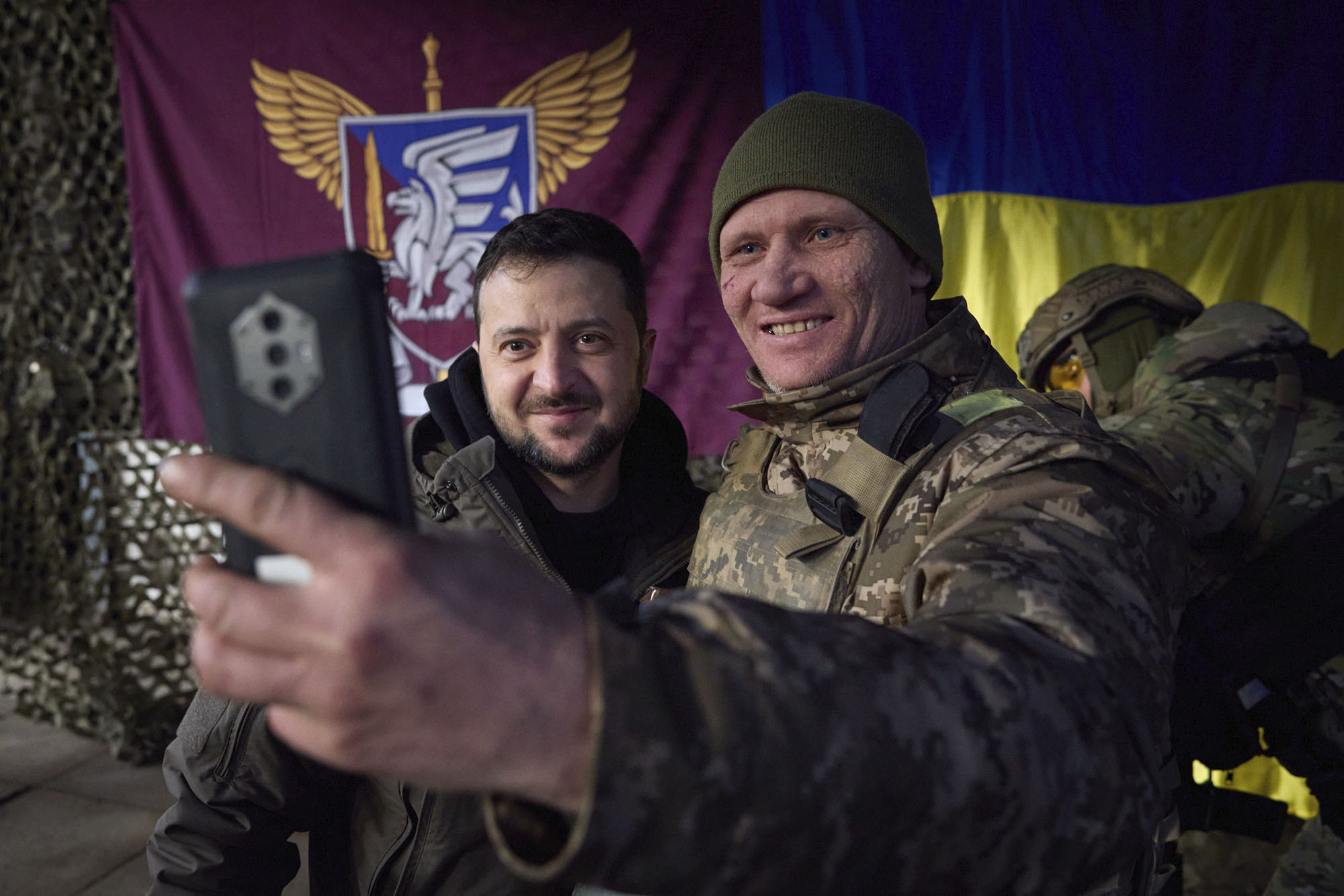 A Ukrainian soldier takes a selfie with President Volodymyr Zelensky, left, during his visit to Sloviansk in the Donbas region, Ukraine, on December 6.