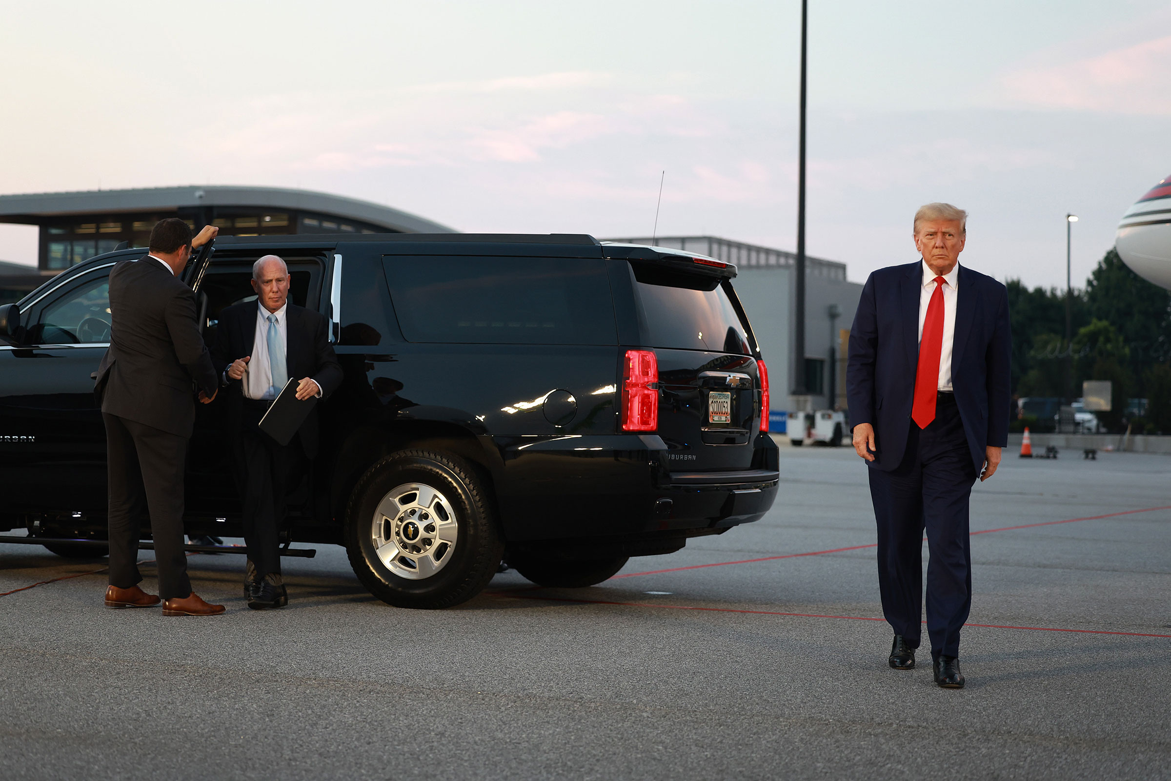 Former President Donald Trump and his lawyer, Steven Sadow, left, arrive at Atlanta Hartsfield-Jackson International Airport after being booked at the Fulton County jail on August 24, in Atlanta, Georgia.