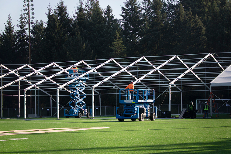 Workers construct a temporary hospital on a soccer field for people infected with COVID-19 on Thursday, March 19,  in Shoreline, Washington. The 200 bed facility will increase hospital capacity in the Seattle area and serve as a place where people infected can isolate and recover. 