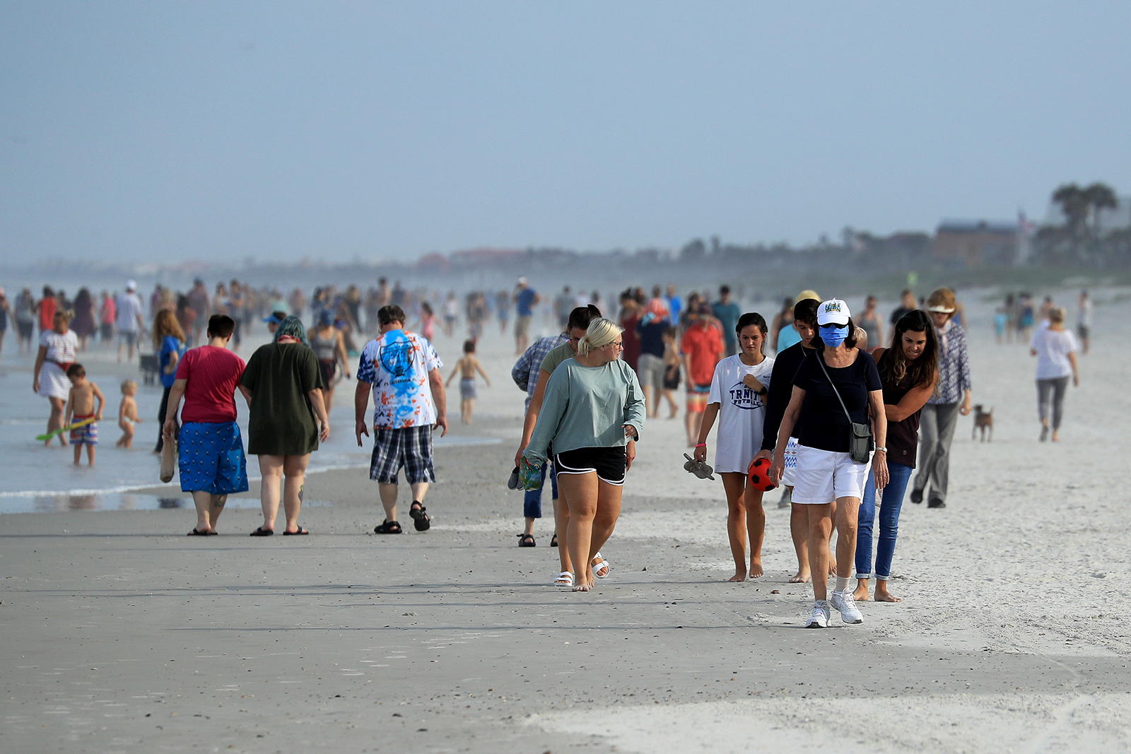 People walk down the beach in Jacksonville Beach, Florida on April 19.