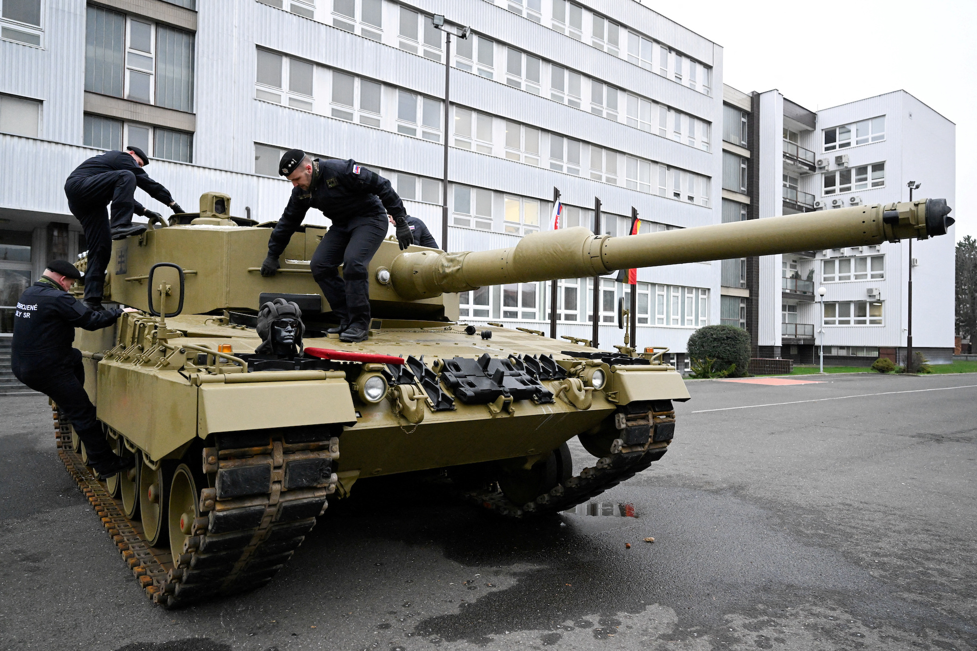 Slovakian military personnel walk on a German Leopard Tank in Bratislava, Slovakia, December 2022.