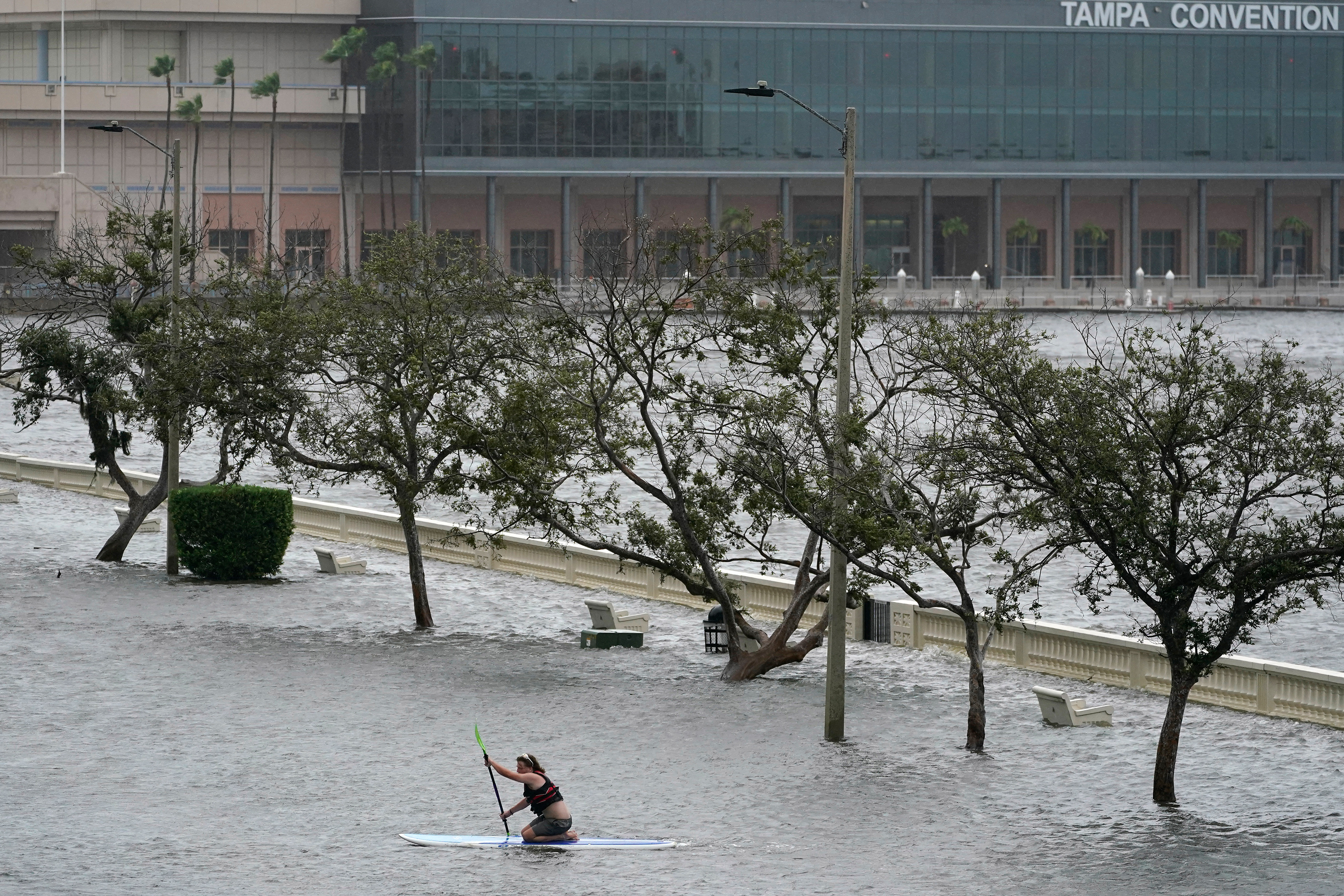 Zeke Pierce rides his paddle board down the middle of a flooded Bayshore Boulevard in Tampa, Florida on August 30.