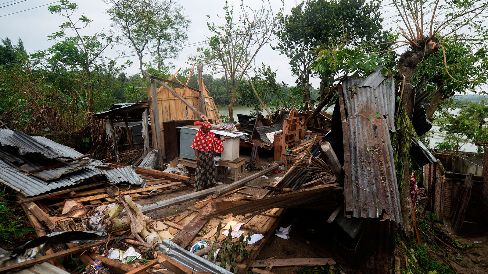 A woman stands amidst the debris of her house damaged by Cyclone Amphan in Satkhira on May 21.