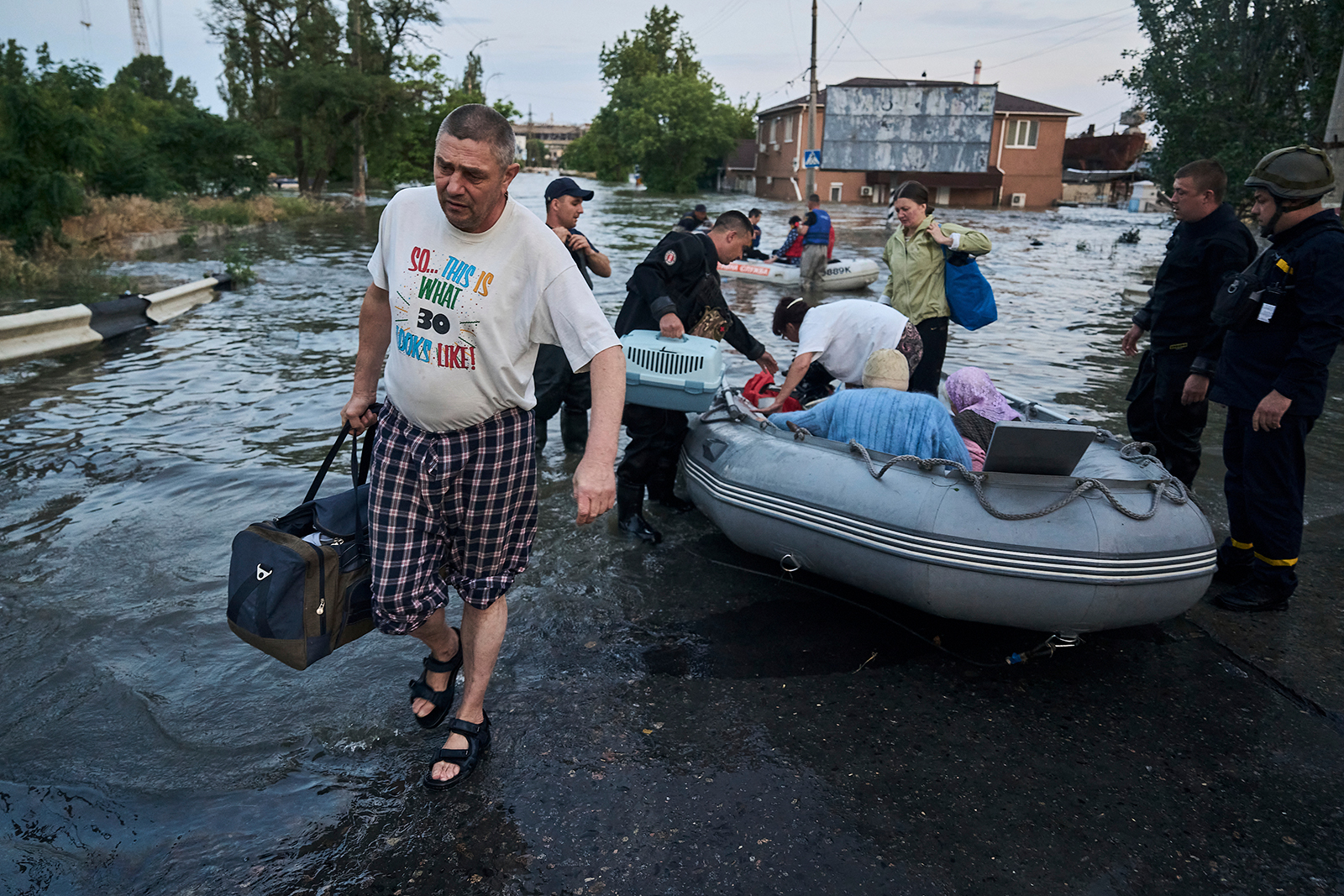 Rescue workers help residents to evacuate from a flooded neighborhood in Kherson, Ukraine on June 6. 