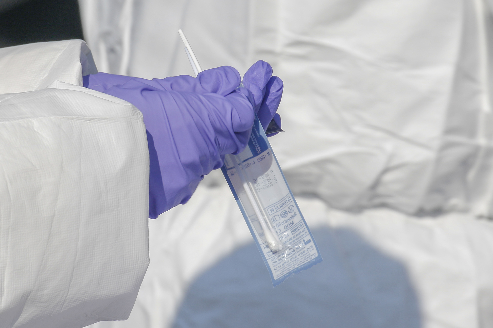 A medical worker collects a specimen for coronavirus testing at a drive-thru clinic in Sangju, South Korea, on January 12, 2021. 