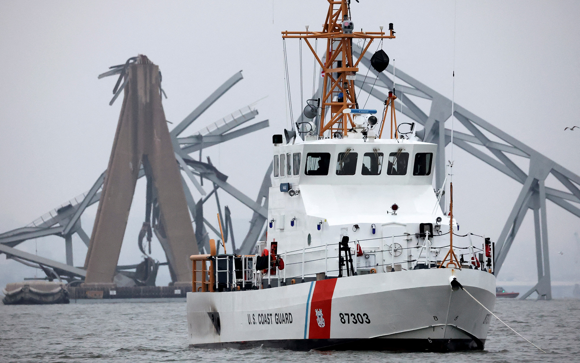 A U.S. Coast Guard vessel sails near the Francis Scott Key Bridge, after the Dali cargo vessel crashed into it causing it to collapse, in Baltimore, Maryland, on March 27.