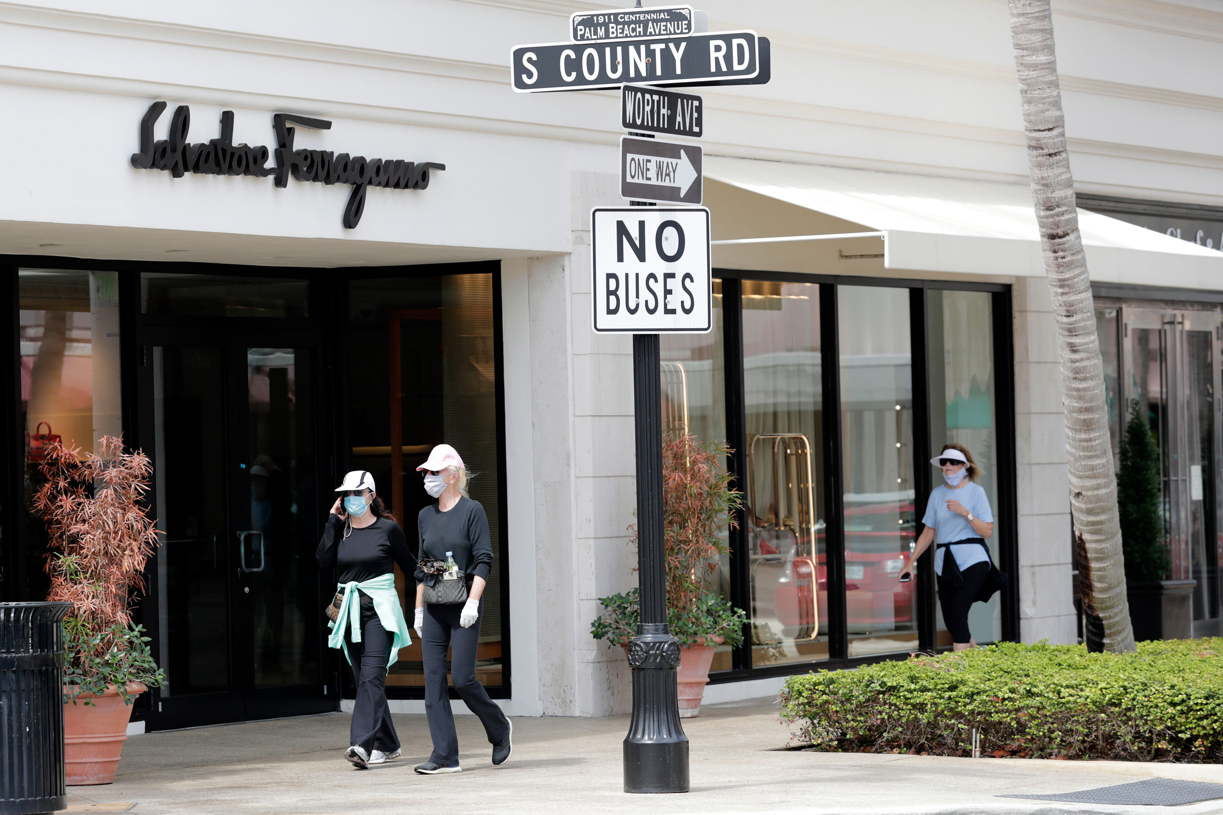 People in Palm Beach, Florida, wear protective face masks as they walk along Worth Avenue on May 11.