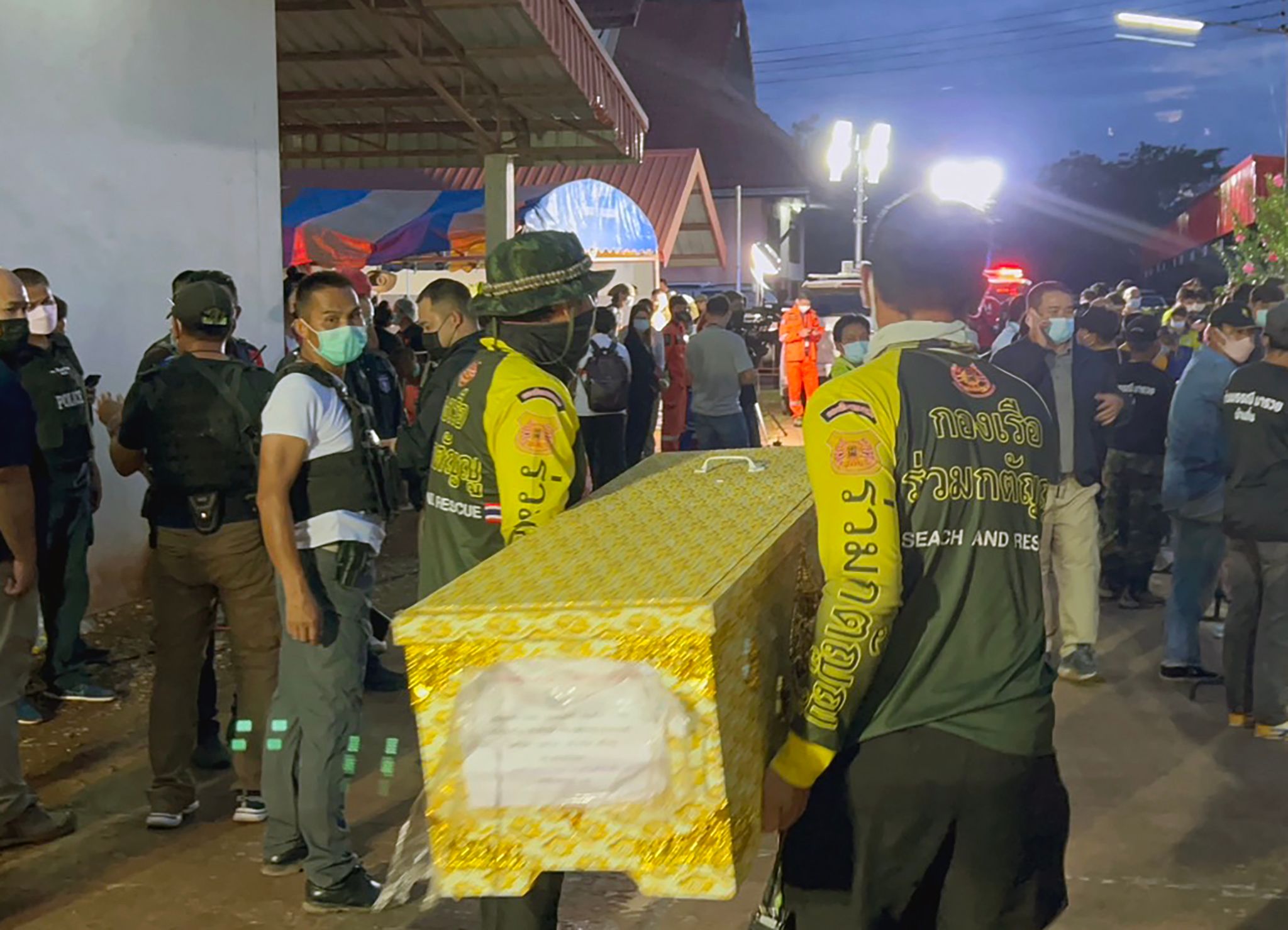 Rescue workers carry a coffin containing a victim of the shooting on Thursday.