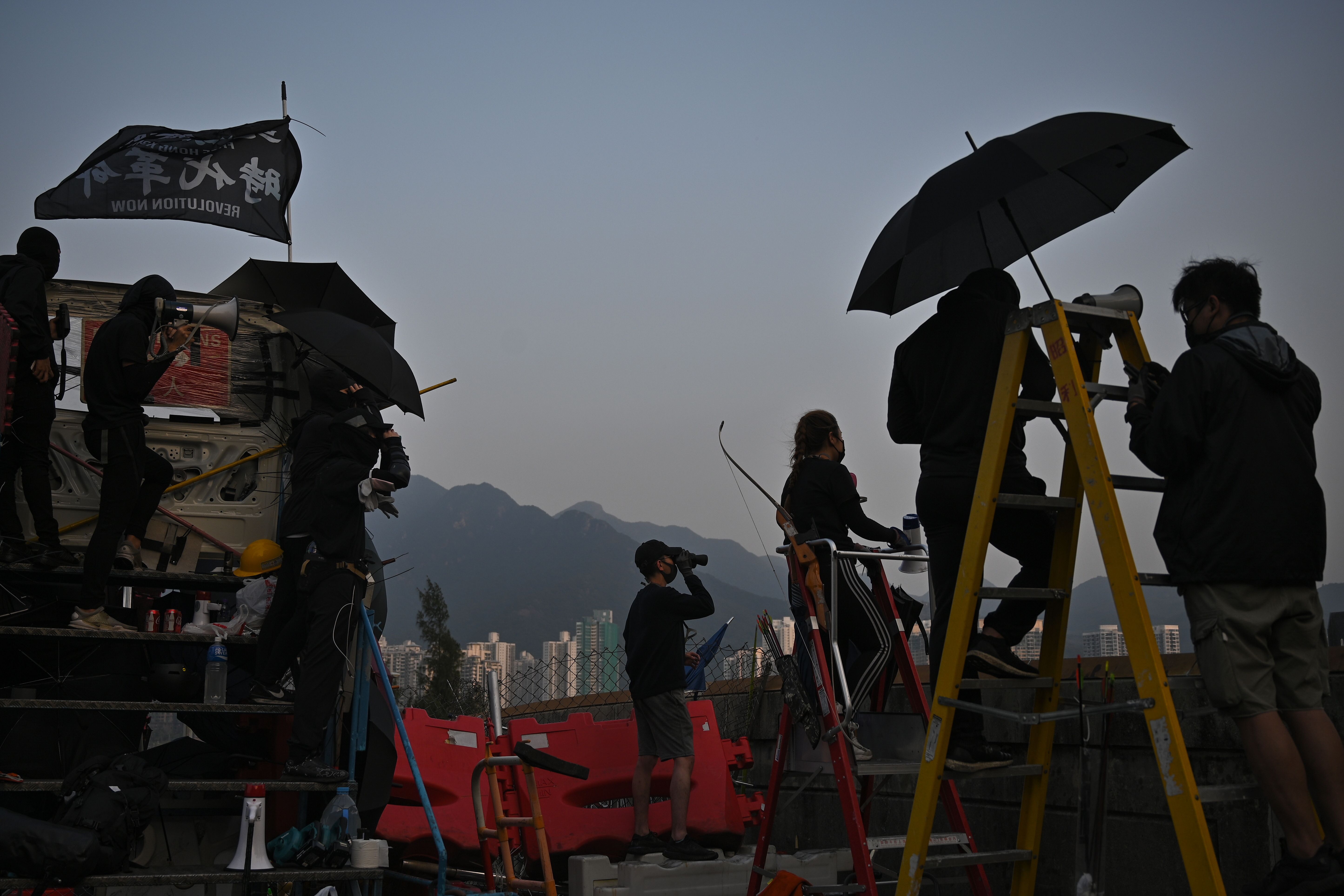 Protesters stand on an observation point on a bridge over the Tolo Highway as they gather at CUHK.