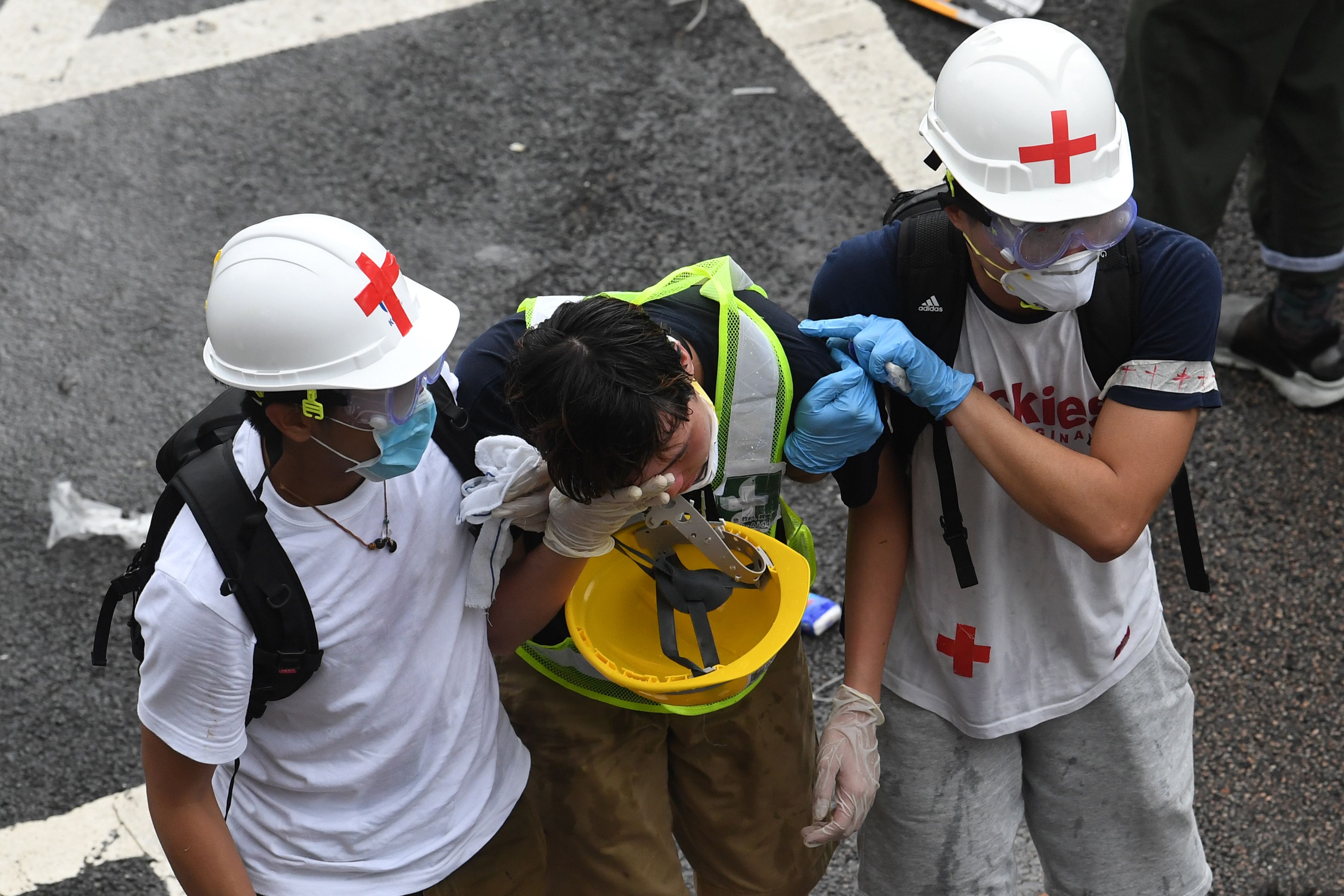 A protester is helped by medical volunteers after being hit by tear gas fired by the police during a rally against a controversial extradition law proposal in Hong Kong on June 12, 2019.