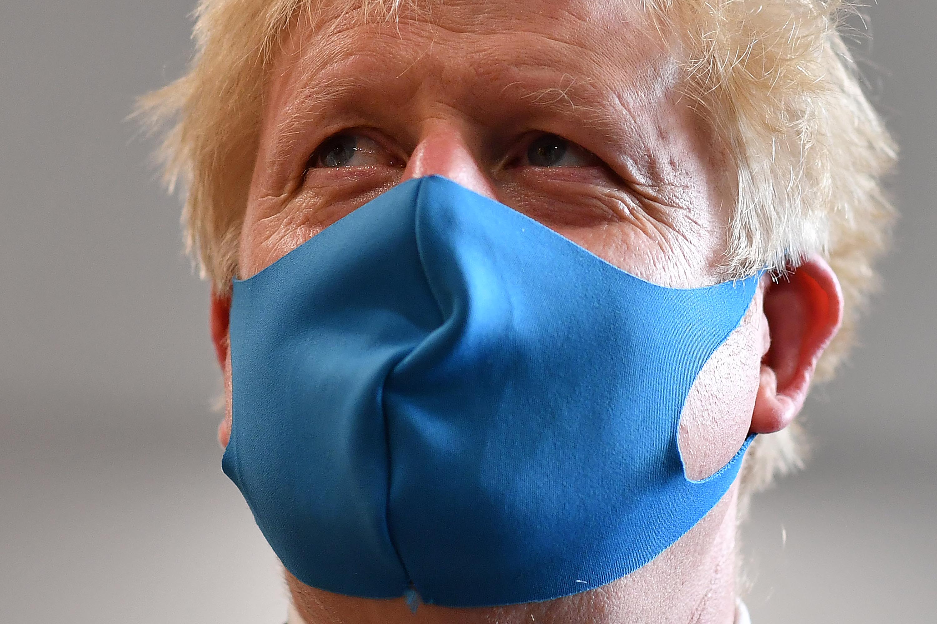 Britain's Prime Minister Boris Johnson wears a face mask while visiting the London Ambulance Service NHS Trust headquarters on July 13 in London, England.
