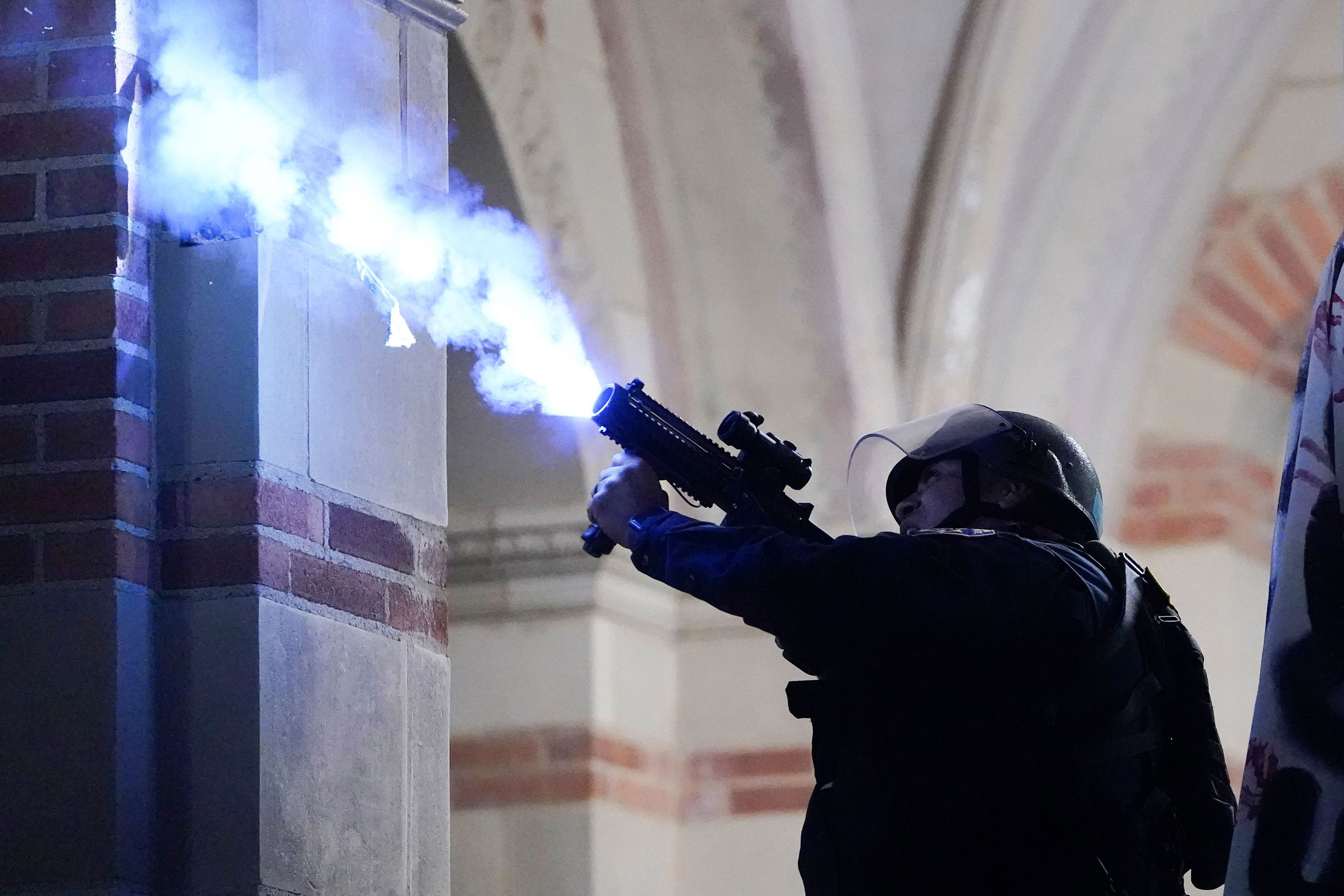 A police officer launches a smoke bomb on the University of California, Los Angeles campus on May 2. 