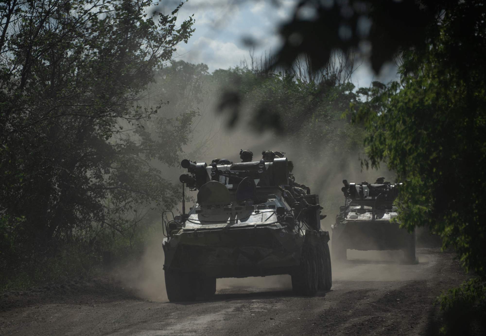 Ukrainian servicemen ride on armored personnel carriers on a road toward Bakhmut on July 1.