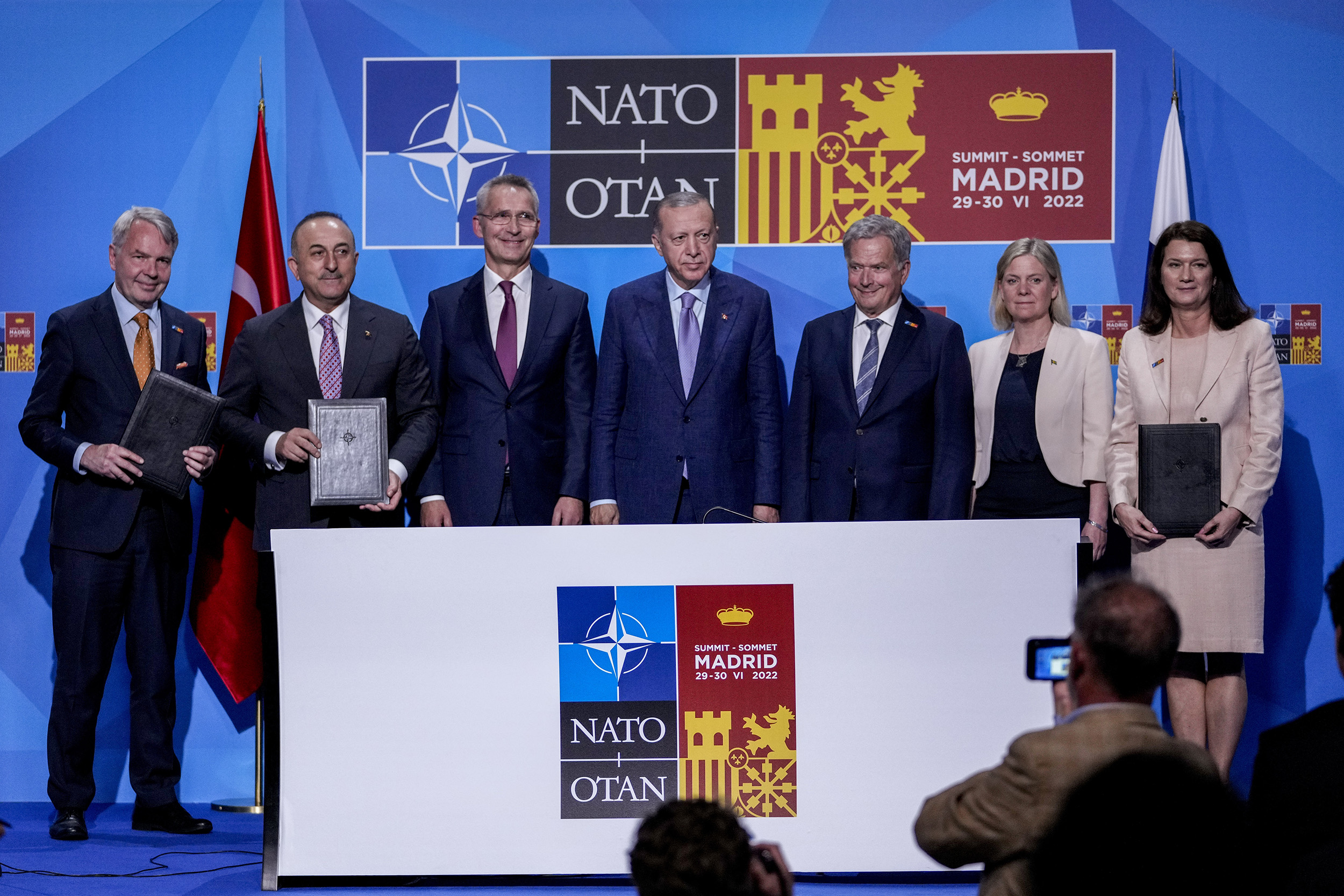 From left to right background: Finnish Foreign Minister Pekka Haavisto, Turkish Foreign Minister Mevlut Cavusoglu, NATO Secretary General Jens Stoltenberg, Turkish President Recep Tayyip Erdogan, Finland's President Sauli Niinisto, Sweden's Prime Minister Magdalena Andersson, and Sweden's Foreign Minister Ann Linde pose for a picture after signing a memorandum in which Turkey agrees to Finland and Sweden's membership of the defense alliance in Madrid, Spain, on June 28