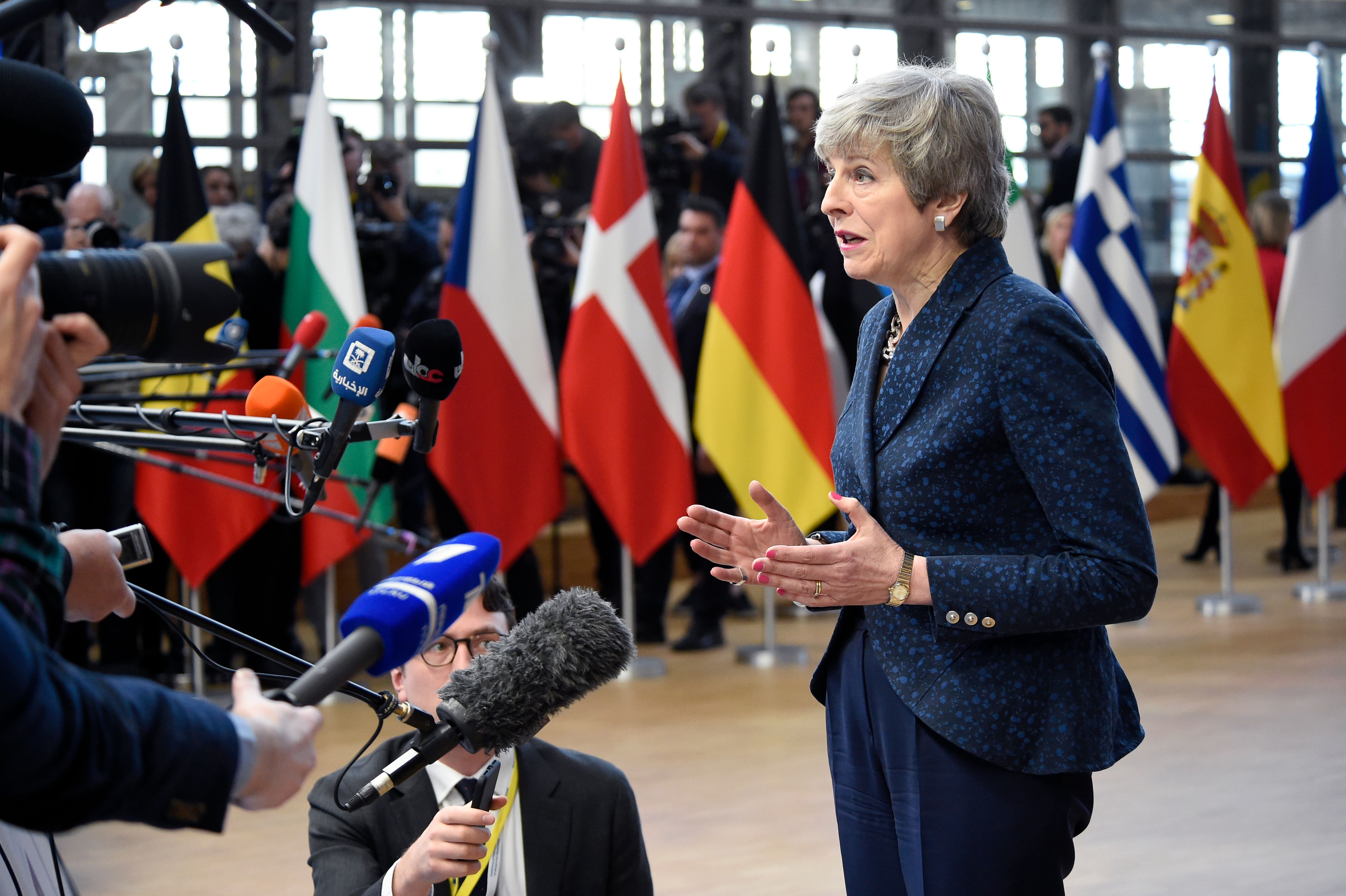Theresa May speaks to reporters after arriving at the EU summit.