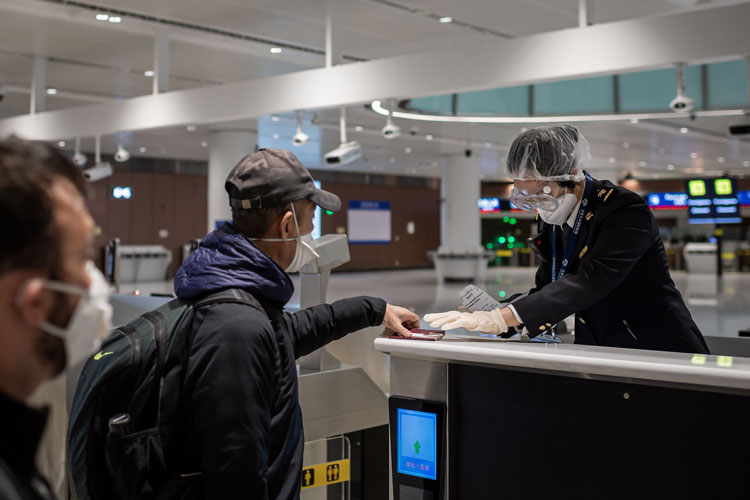 A quarantine officer checks health documents from arriving passengers before they pass through customs at Beijing Daxing International Airport on Friday, February 14.
