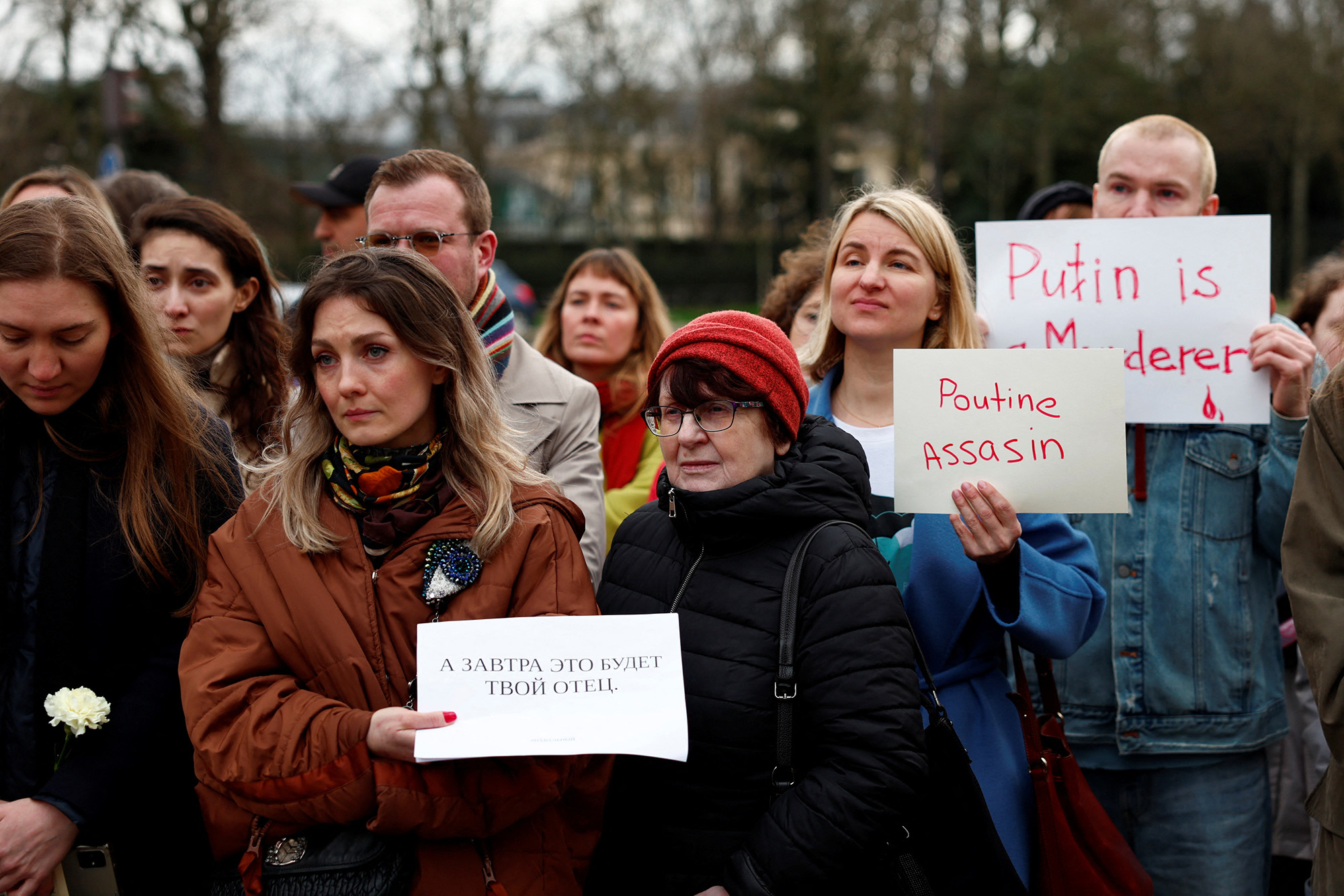 People hold placards as they gather near the Russian embassy following the death of Russian opposition leader Alexey Navalny, in Paris, France, on February 16.