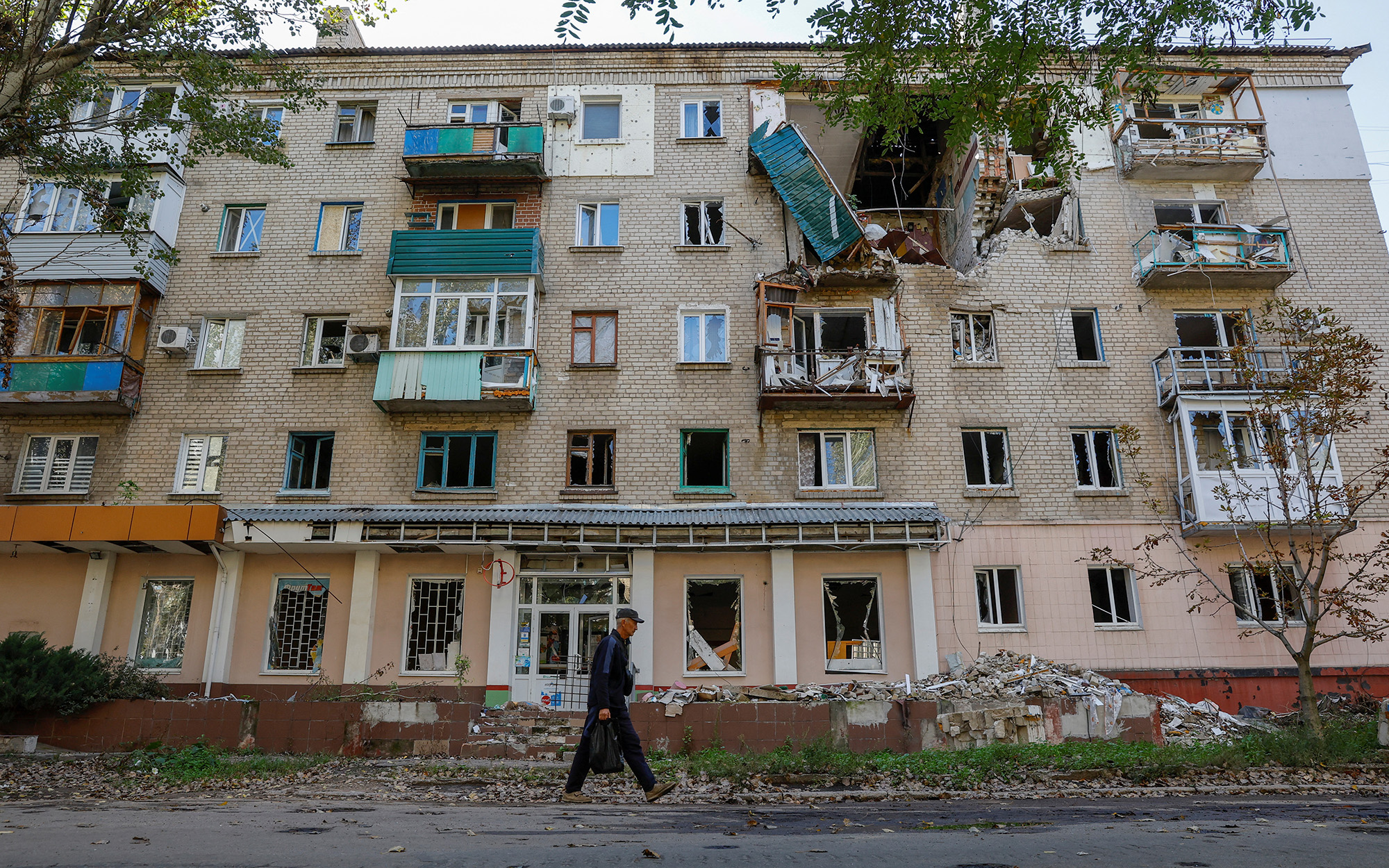 A man walks past a residential building in Lysychansk, the city controlled by pro-Russian troops in the Luhansk region, Ukraine, on September 21.