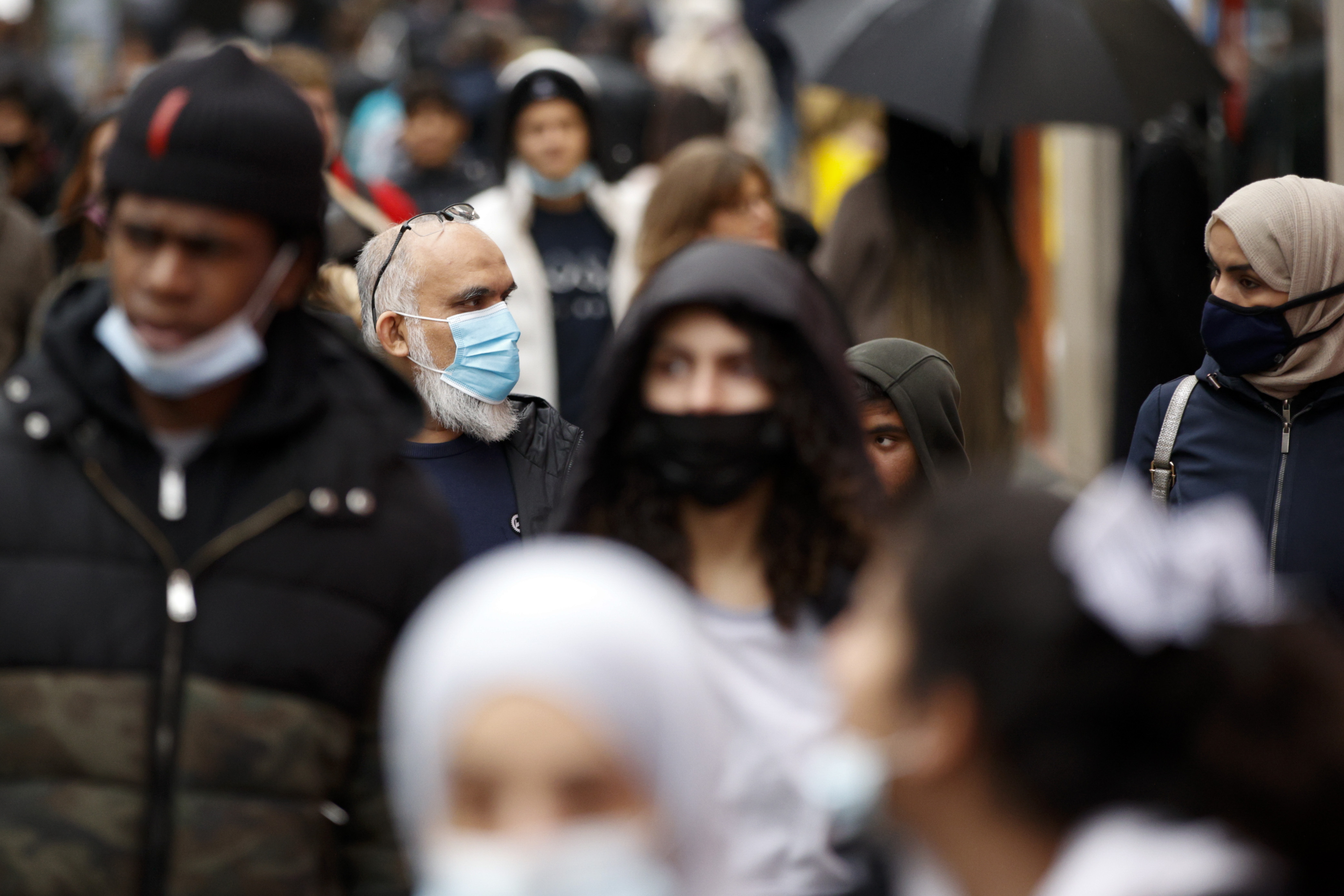 Shoppers, some wearing face masks to guard against COVID-19, walk along Oxford Street in London, Monday, December 27, 2021. 