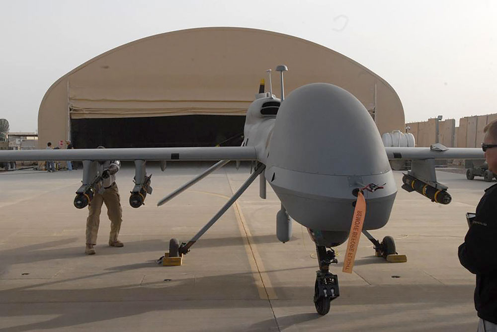 Contactors from General Atomics load Hellfire missiles onto an MQ-1C Gray Eagle at Camp Taji, Iraq, in February 2011.