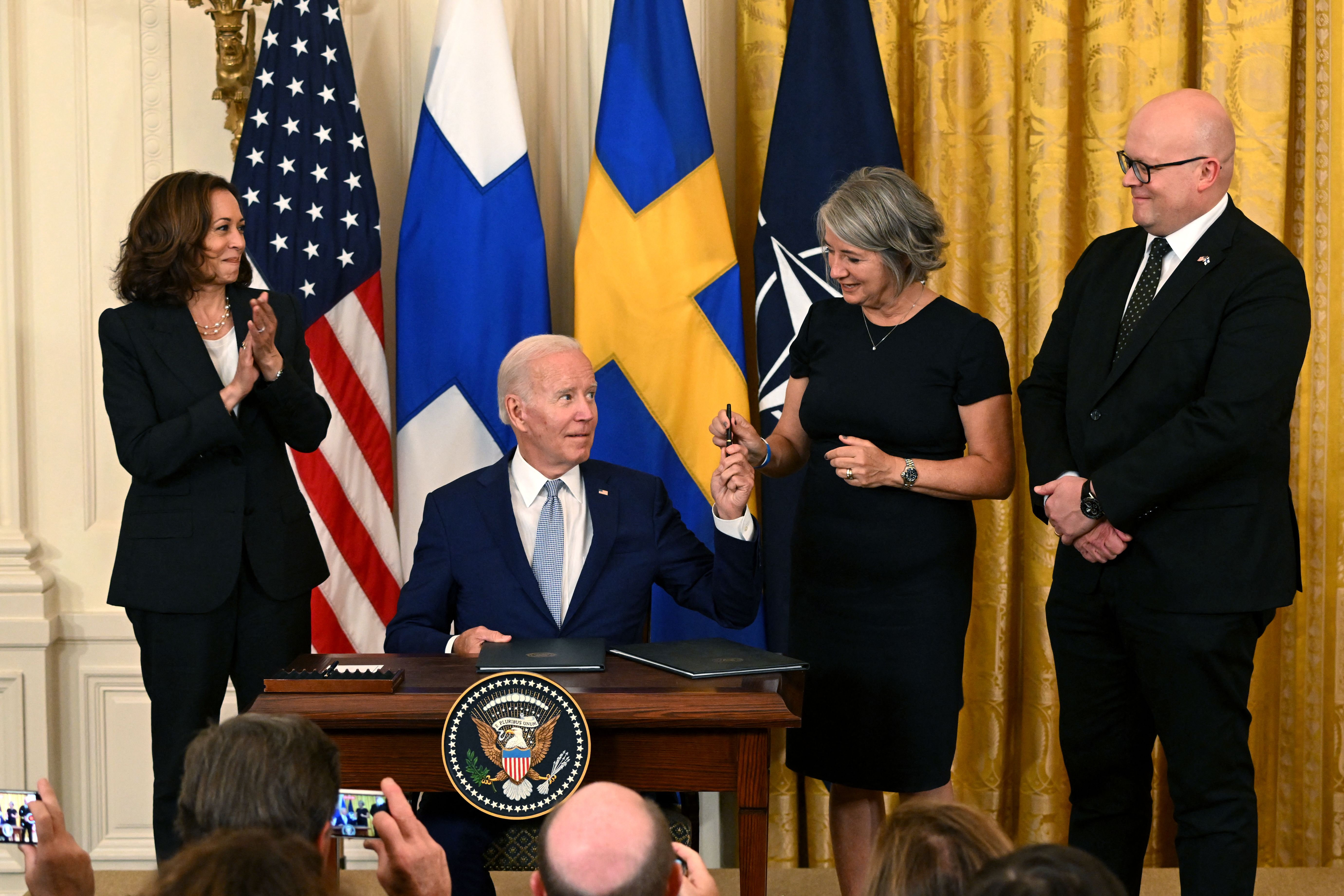 US Vice President Kamala Harris, left, and Ambassador Mikko Hautala, of Finland, right, look on as US President Joe Biden hands a pen to Ambassador Karin Olofsdotter, of Sweden, during a signing ceremony in the East Room of the White House in Washington, DC, on August 9.