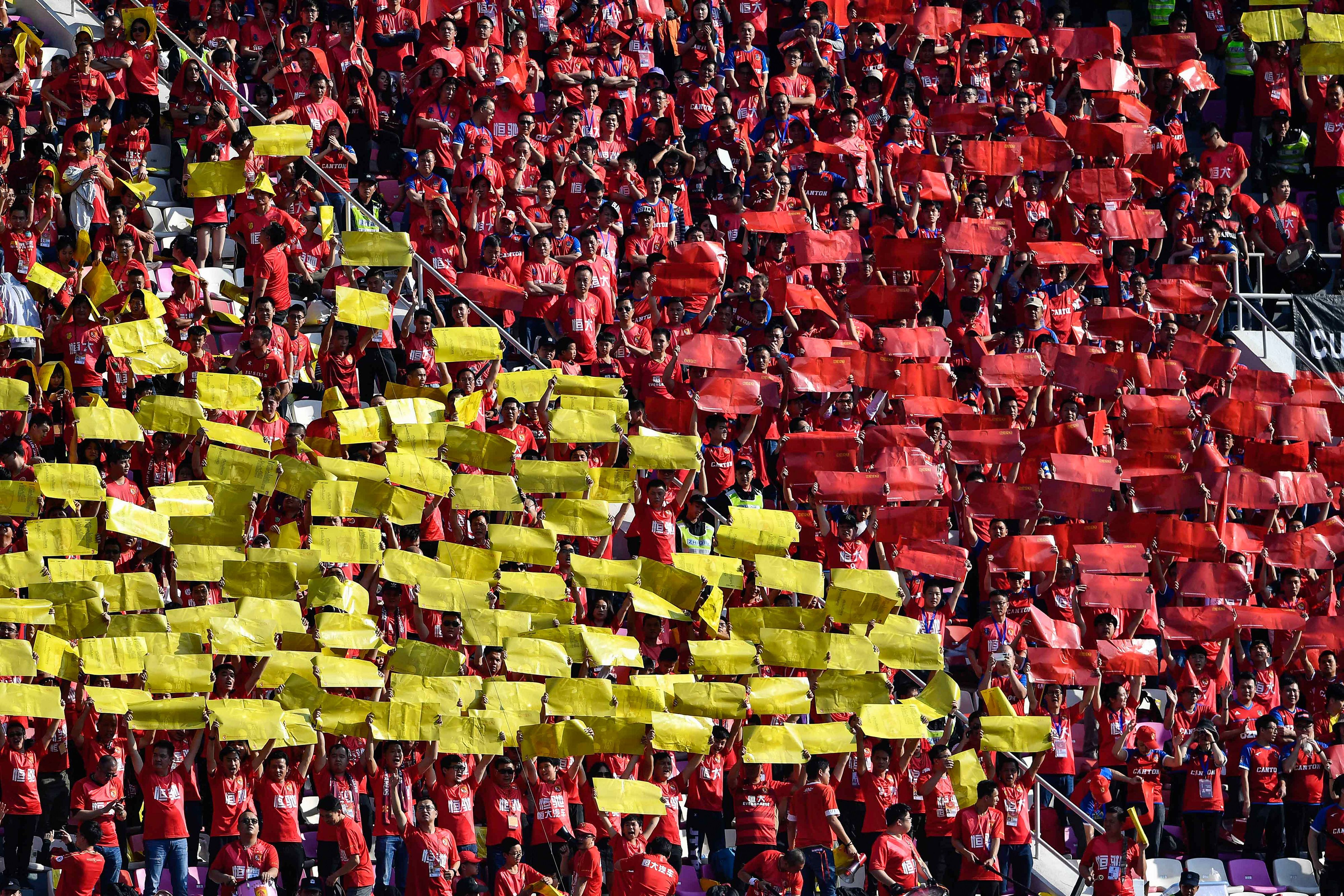 Fans of Guangzhou Evergrande cheer for the team during the Chinese Super League (CSL) match between Guangzhou Evergrande and Shanghai Shenhua in Guangzhou.