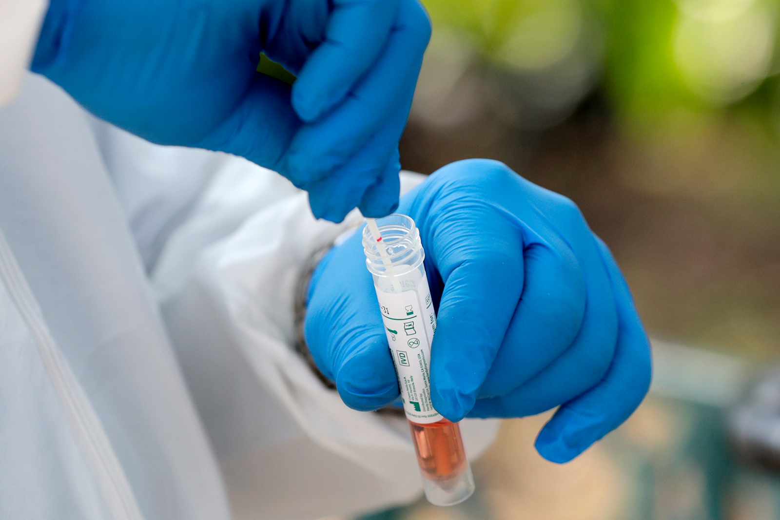 A medical worker places a swab in a vial while testing on April 16 in Miami.
