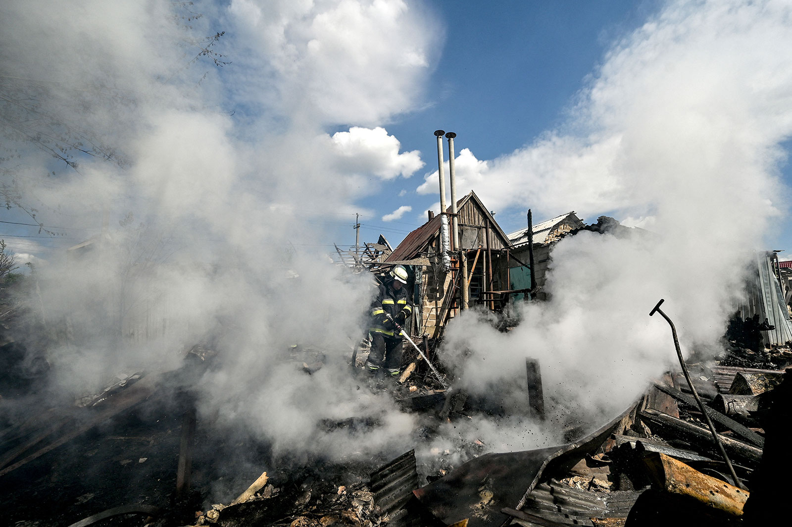 A fire fighter works to put out a fire at a house destroyed by a Russian attack on Malokaterynivka, in the Zaporizhzhia Region of Ukraine,  on Thursday, May 11th