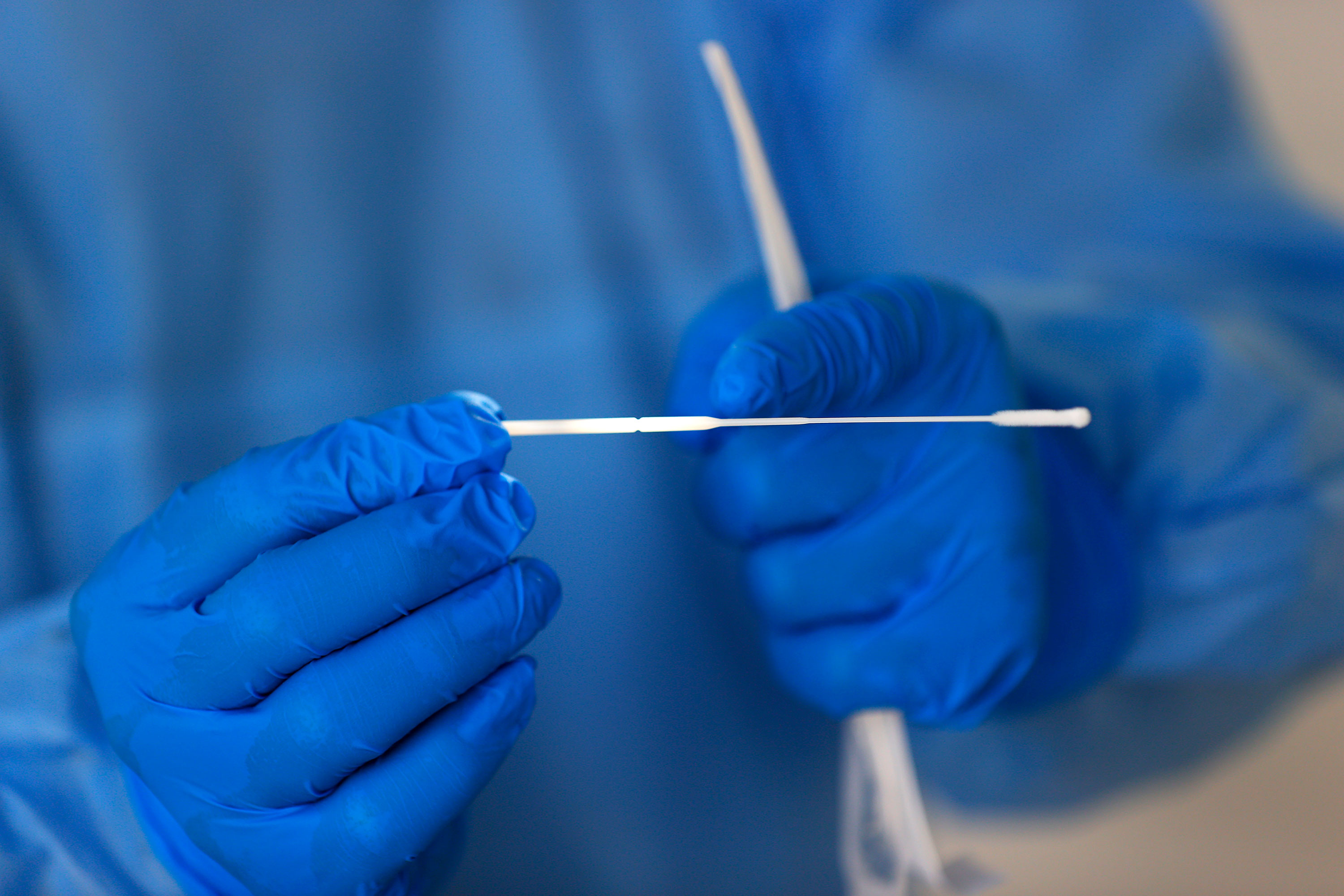 A worker shows a coronavirus test swab in Fort Worth, Texas, on June 9.