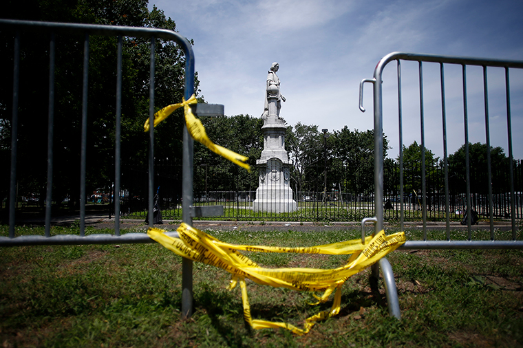 A statue of Christopher Columbus is seen behind barricades at Marconi Plaza, Monday, June 15, in Philadelphia.