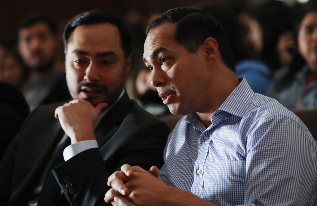 Democratic presidential candidate Julian Castro (R) and his twin brother US Rep. Joaquin Castro (D-TX) sit at a campaign appearance at Bell Gardens High School on March 4, 2019 in Bell Gardens, California.