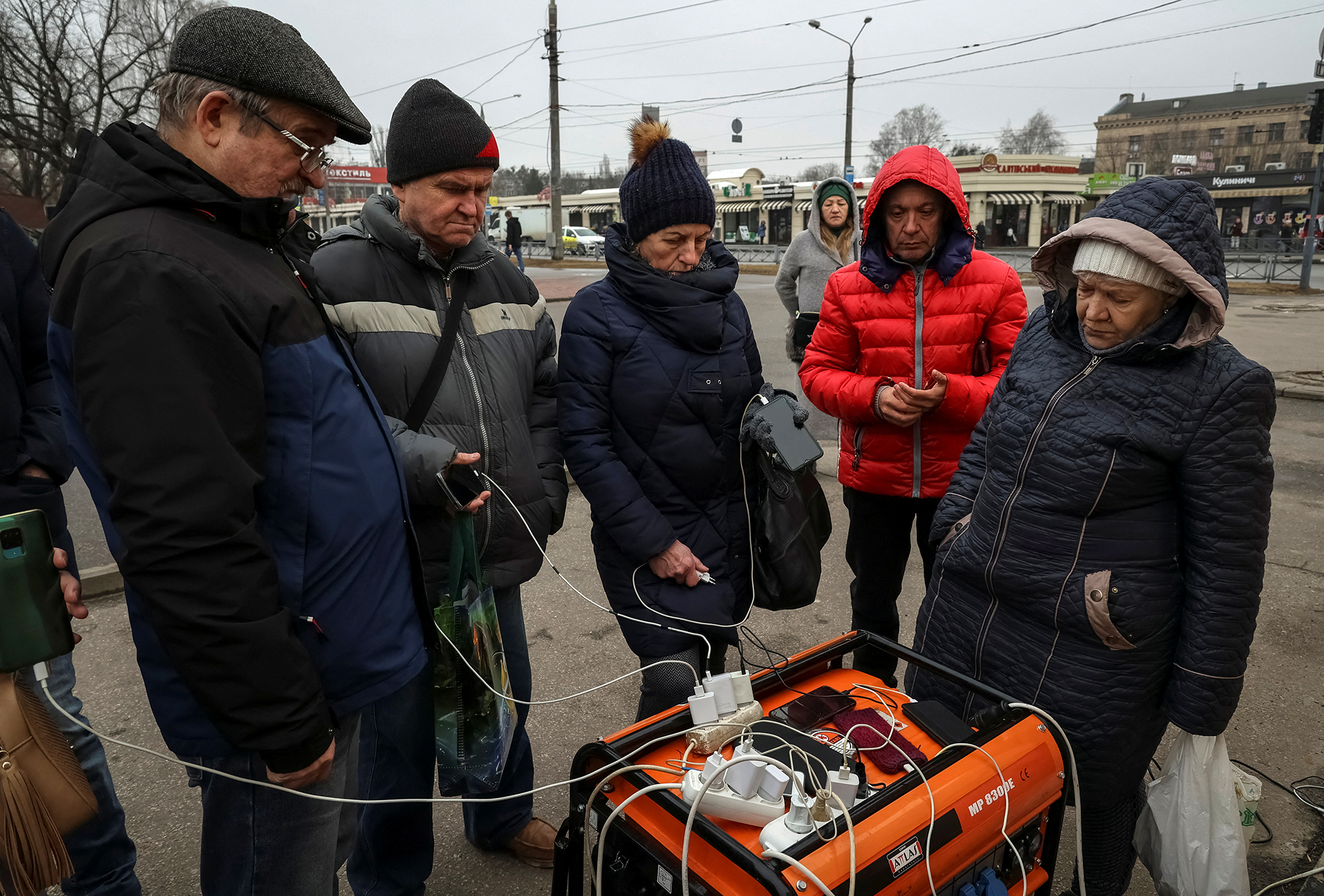 Local residents charge their phones using a generator during a power outage after critical civil infrastructure was hit by Russian missile attacks, in Kharkiv, Ukraine, on March 9.