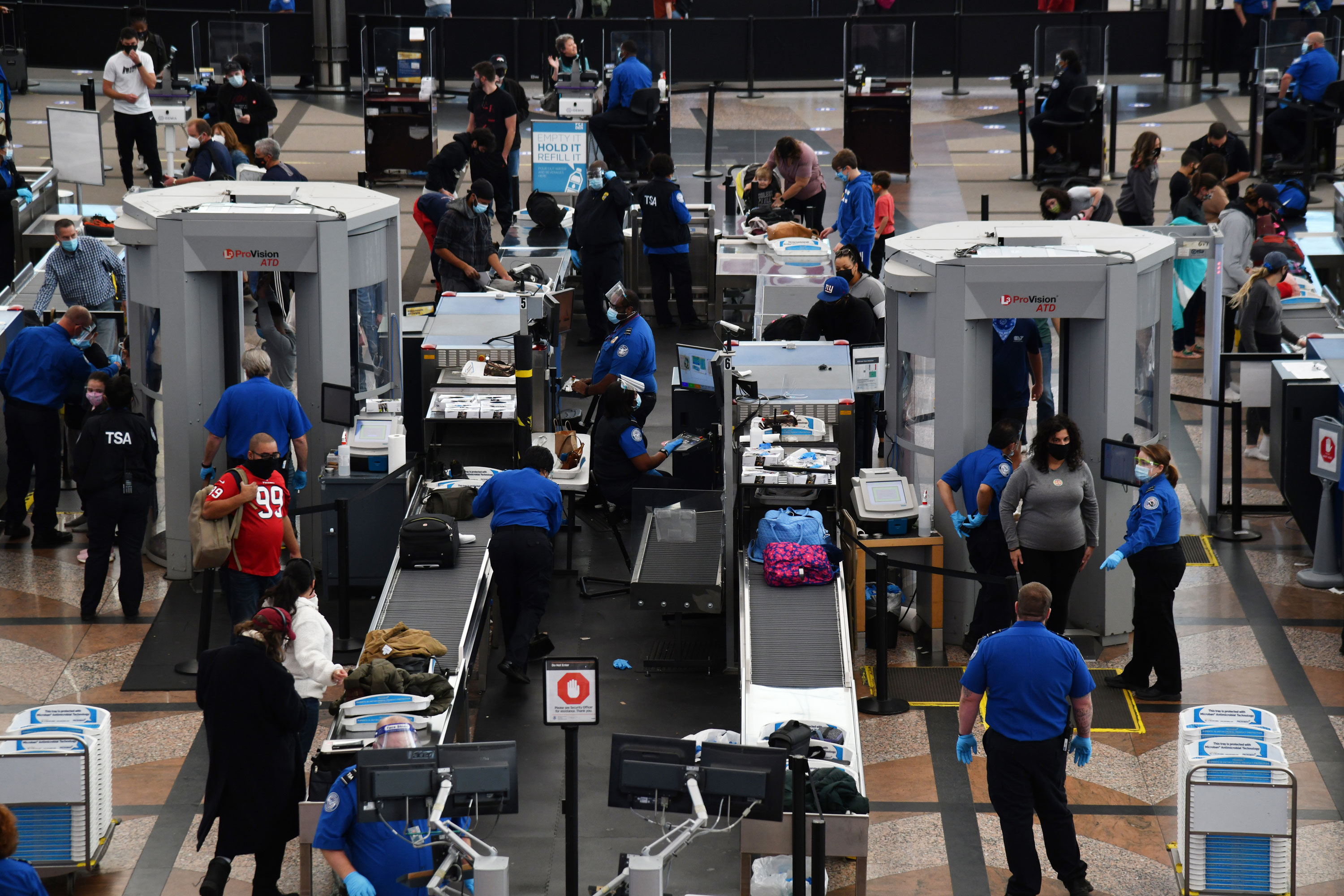 Transportation Security Administration workers check travelers' luggage at Denver International Airport in Colorado on November 20, 2020.