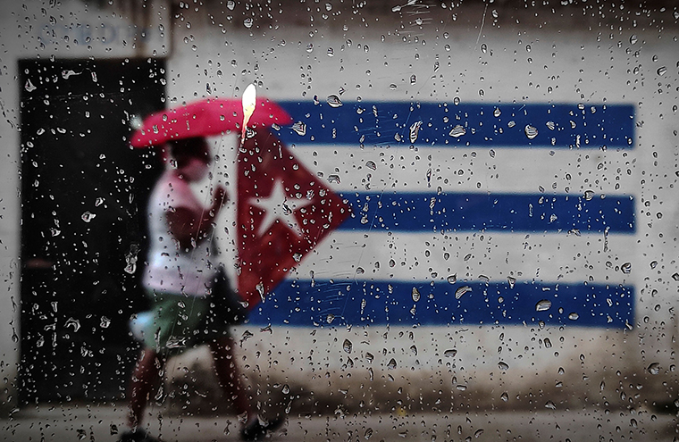 A woman walks near a graffiti with the Cuban flag in Havana, on January 12, 2021.