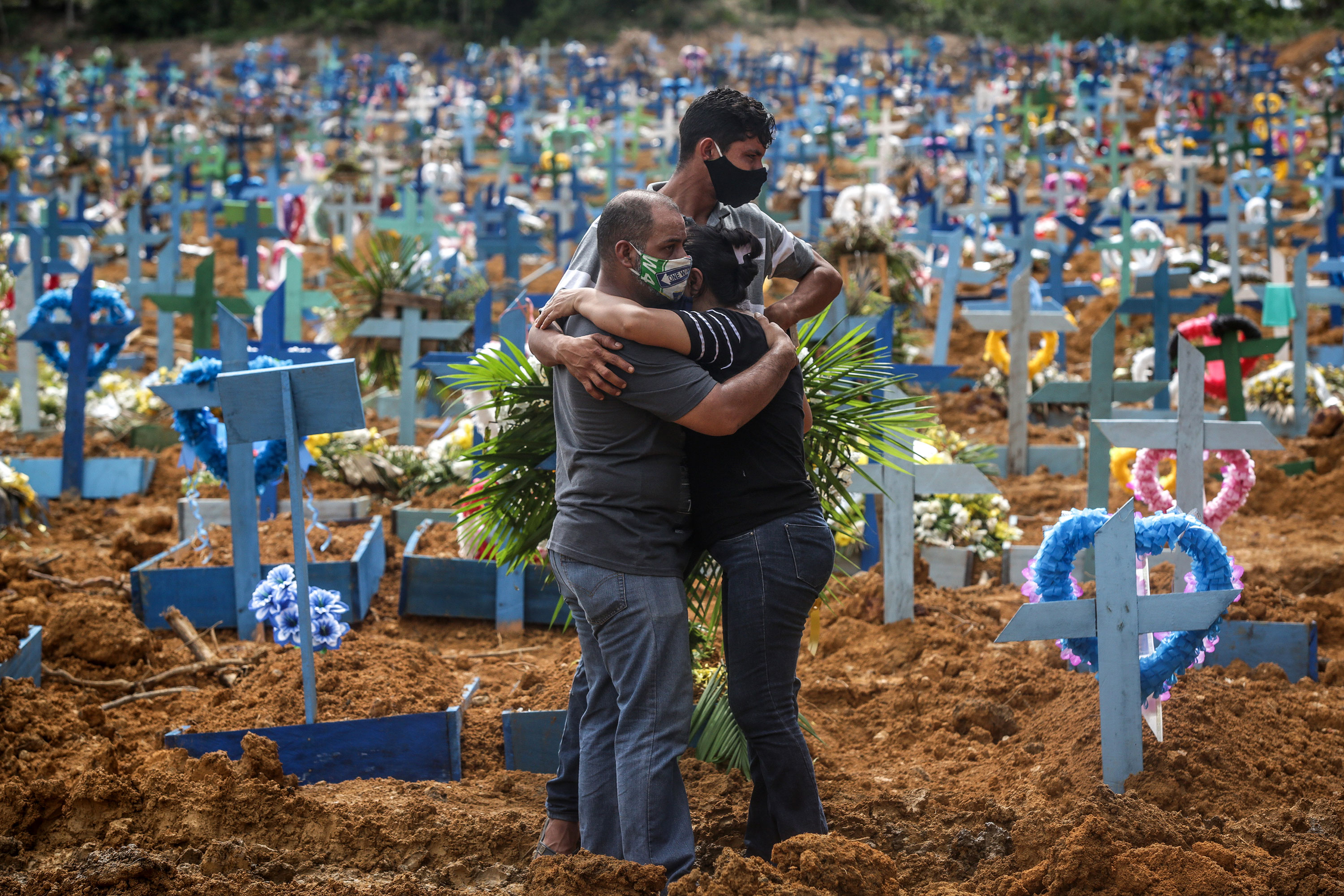 People mourn during a mass burial of coronavirus victims at the Parque Taruma cemetery in Manaus, Brazil, on May 19.