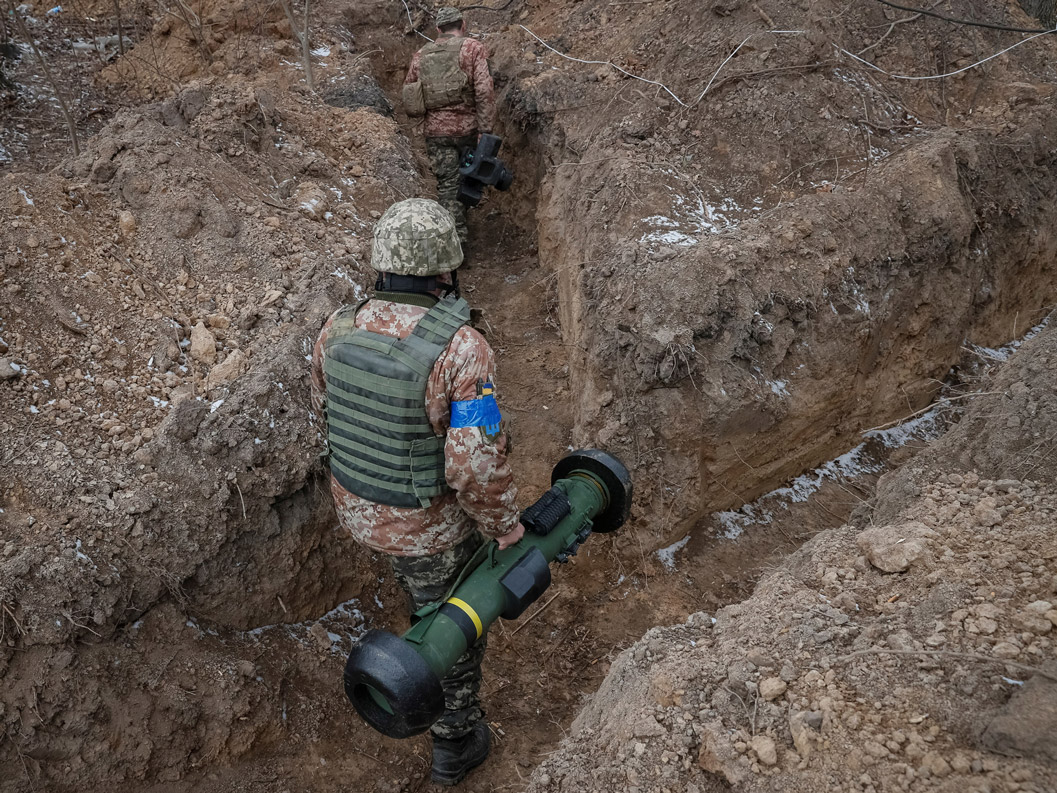 In this file photo, a Ukrainian service member carries an American-made Javelin missile system in a trench position north of Kyiv, on March 13.