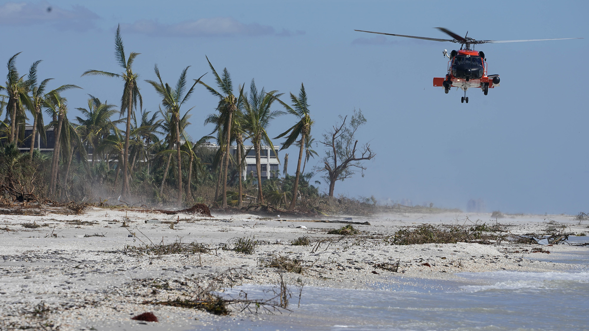 A U.S. Coast Guard helicopter prepares to land on a beach to ferry people off Sanibel Island, Florida, on Friday, September 30.