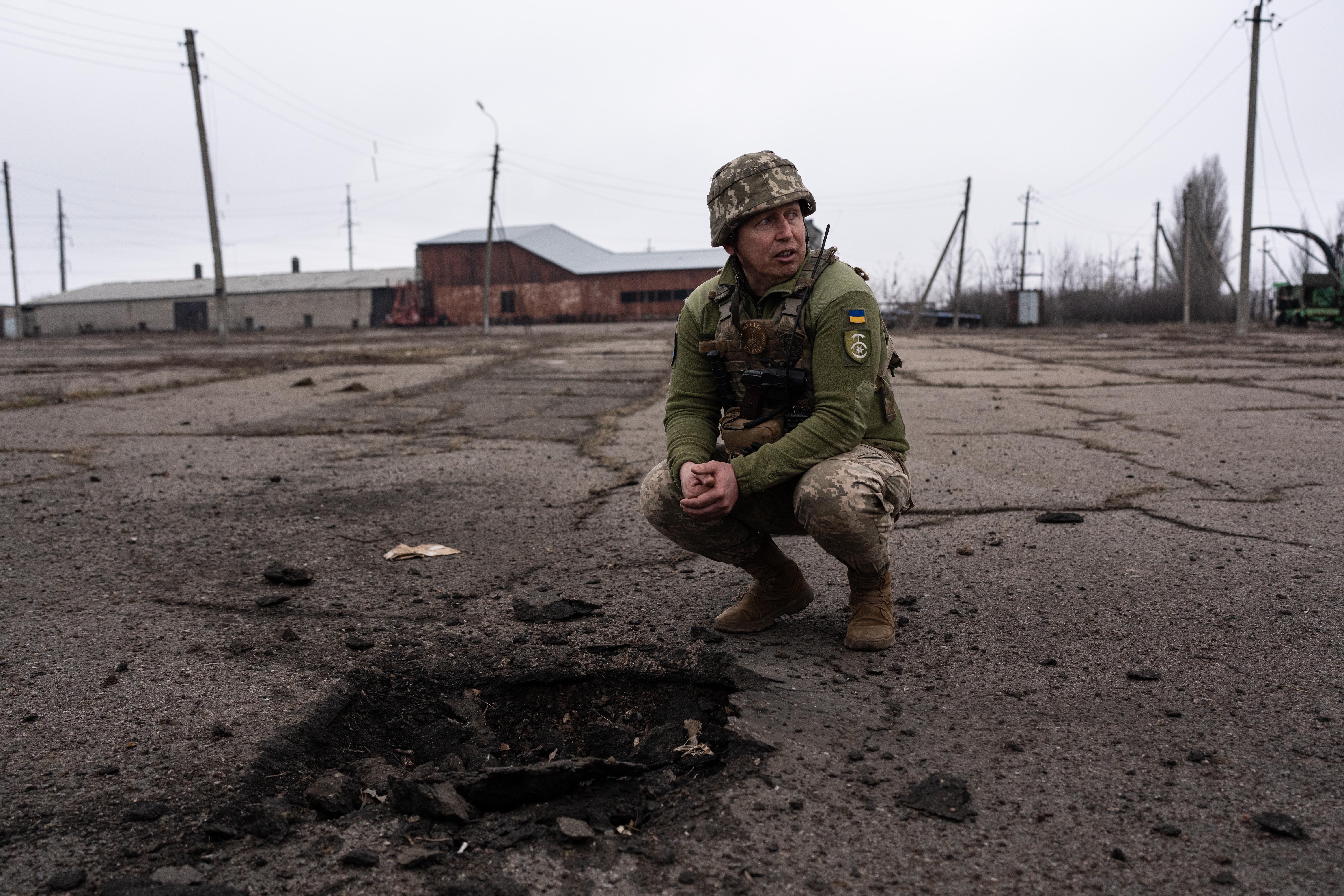 A Ukrainian commander shows the impact crater of an 82mm mortar in the town of Novaluhans'ke, Ukraine on February 22.