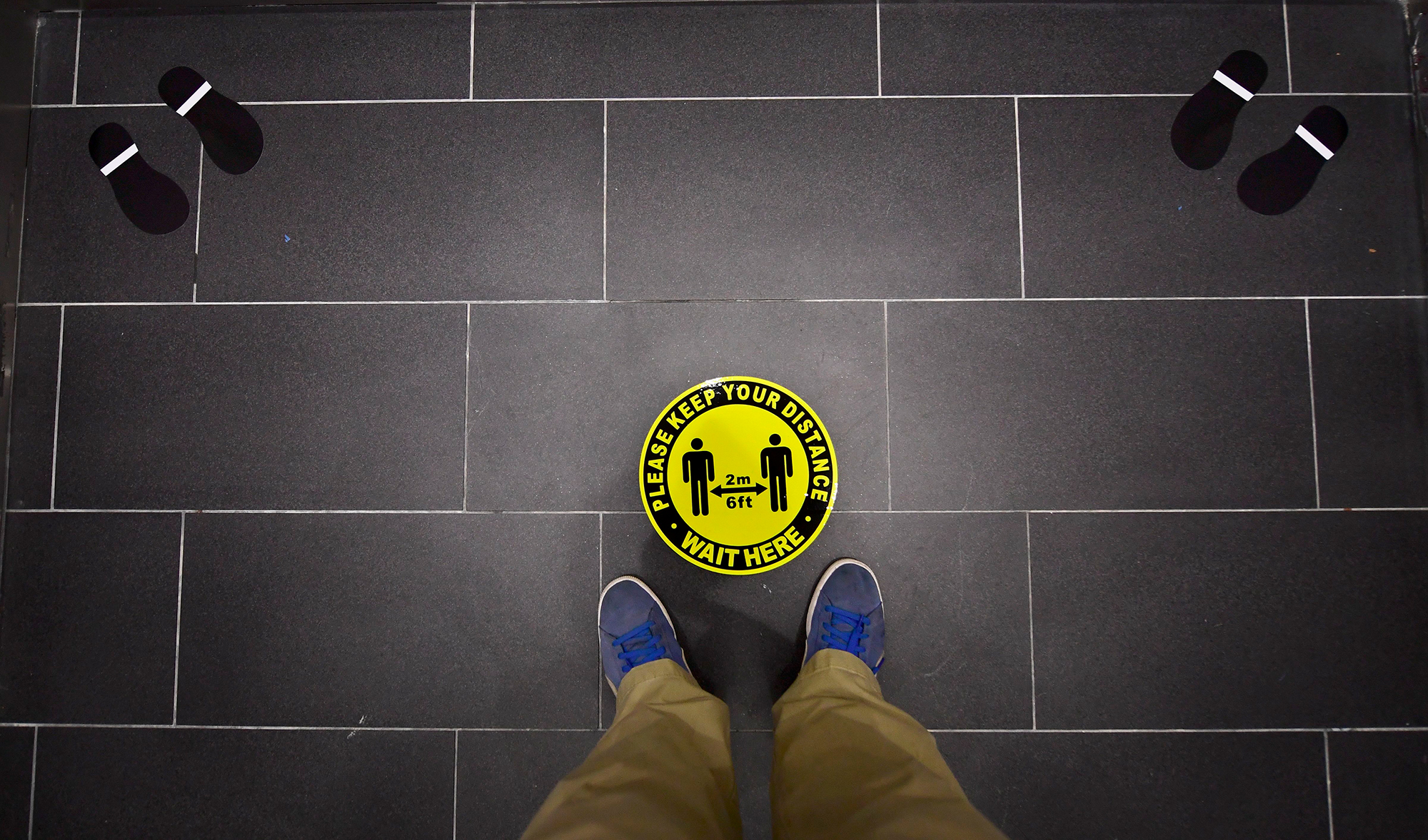 Foot markings and a coronavirus social distance reminder are seen on the floor of an elevator in office building in Hollywood, California on July 7, 2020. 