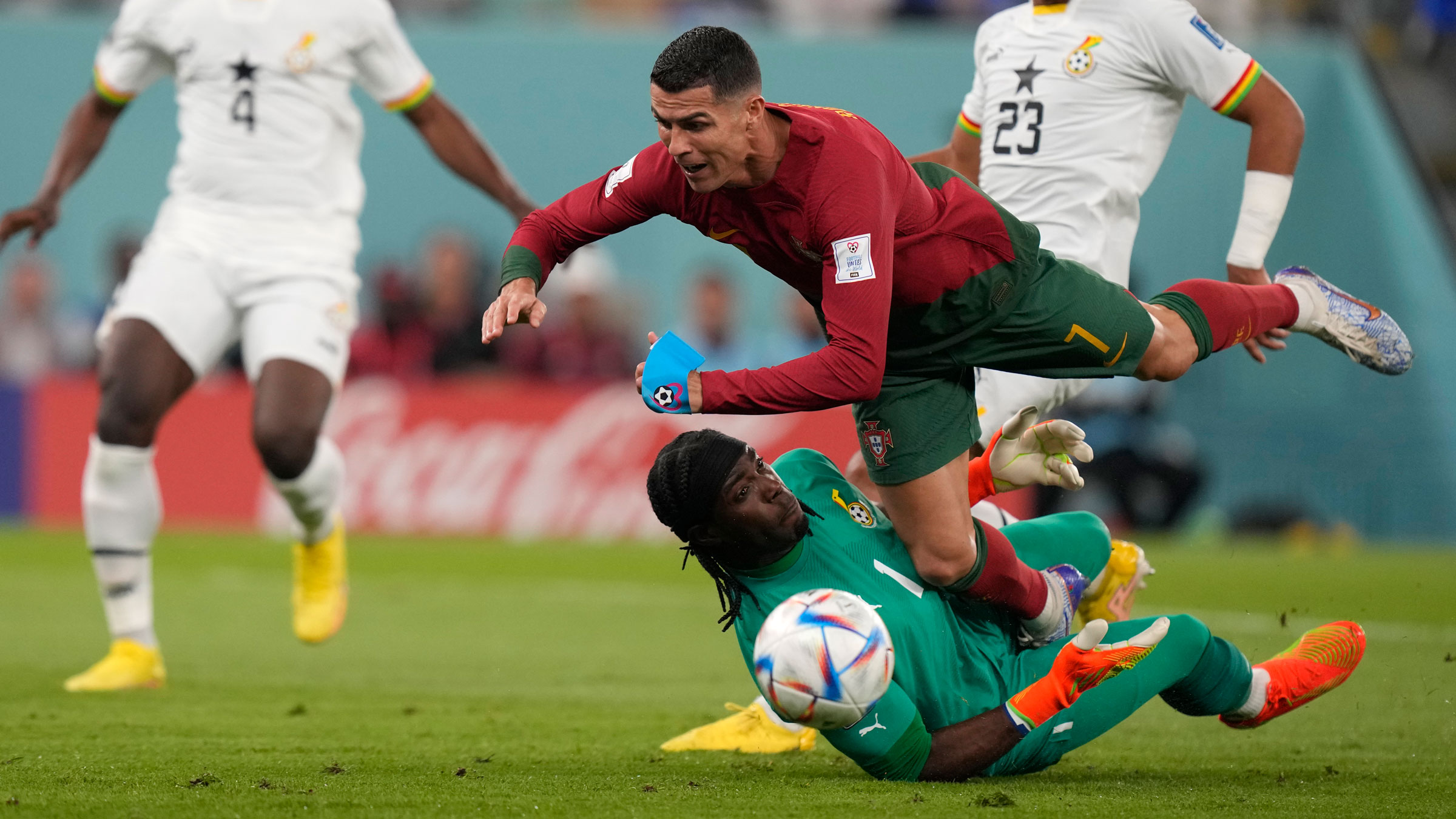 Portugal's Cristiano Ronaldo falls over Ghana goalkeeper Lawrence Ati-Zigi.