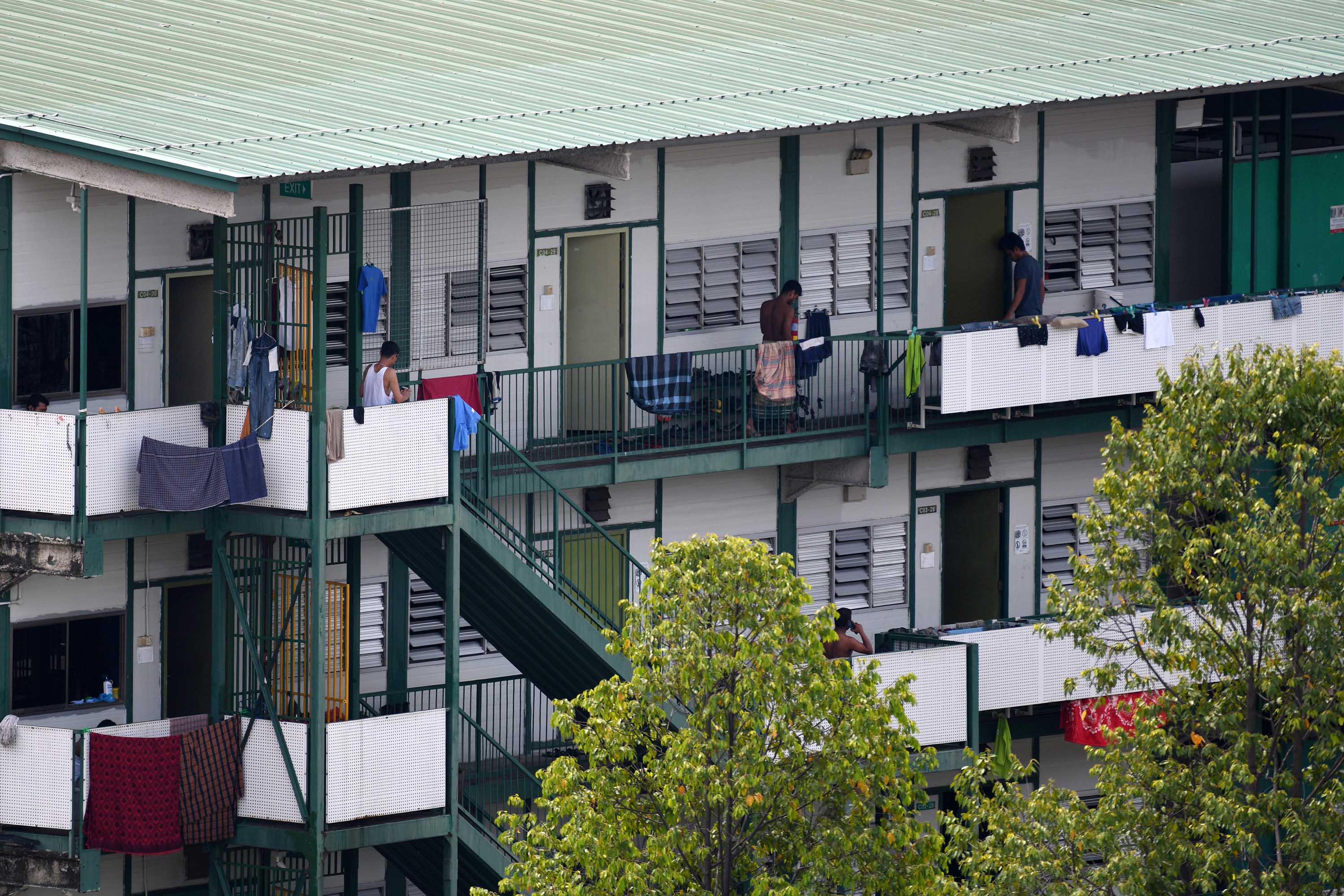 Men stand on the balcony of a dormitory used to house migrant workers in Singapore on April 17.