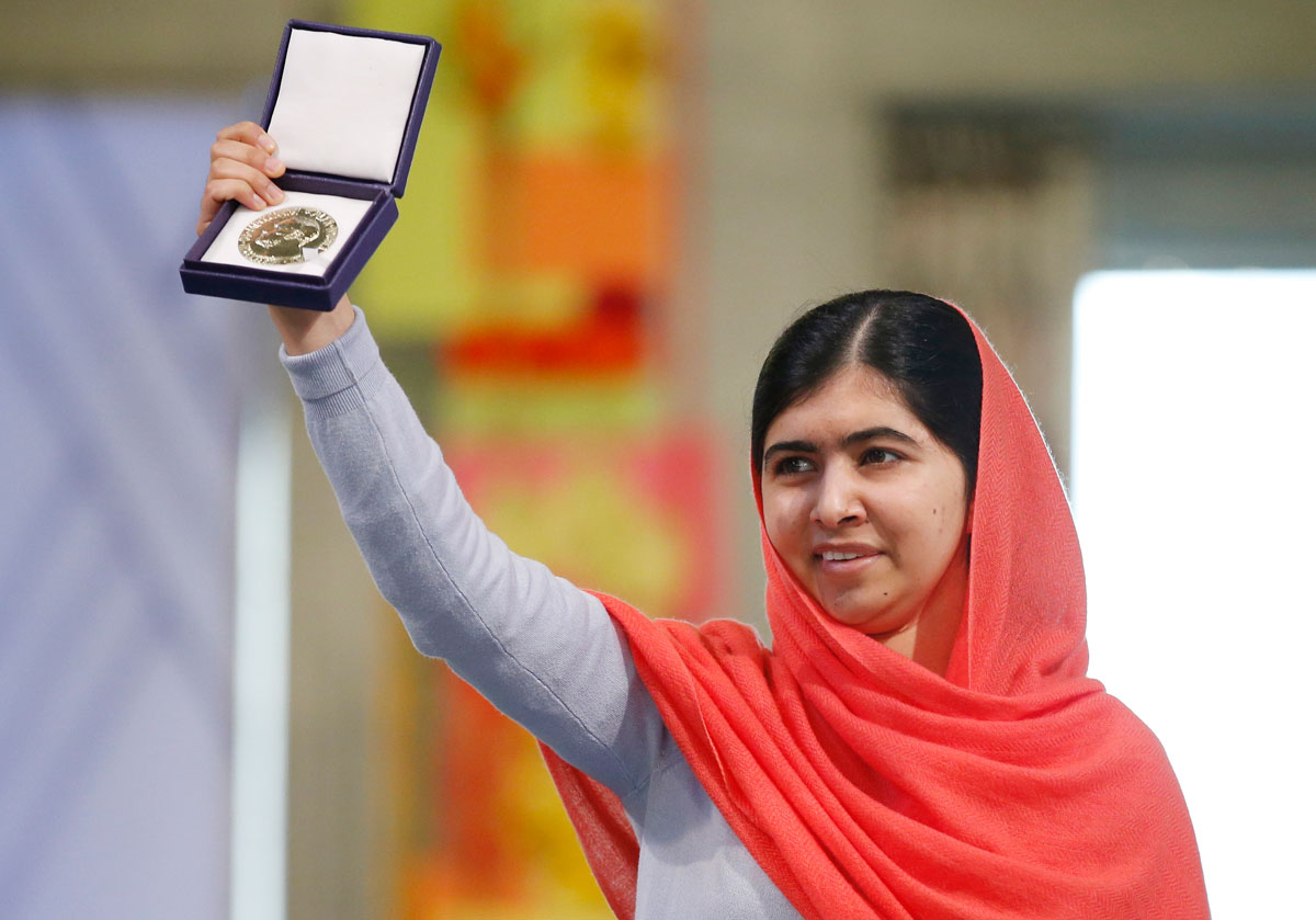 Malala Yousafzai holds up her medal during the Nobel Peace Prize award ceremony in Oslo, Norway, on December 10, 2014.