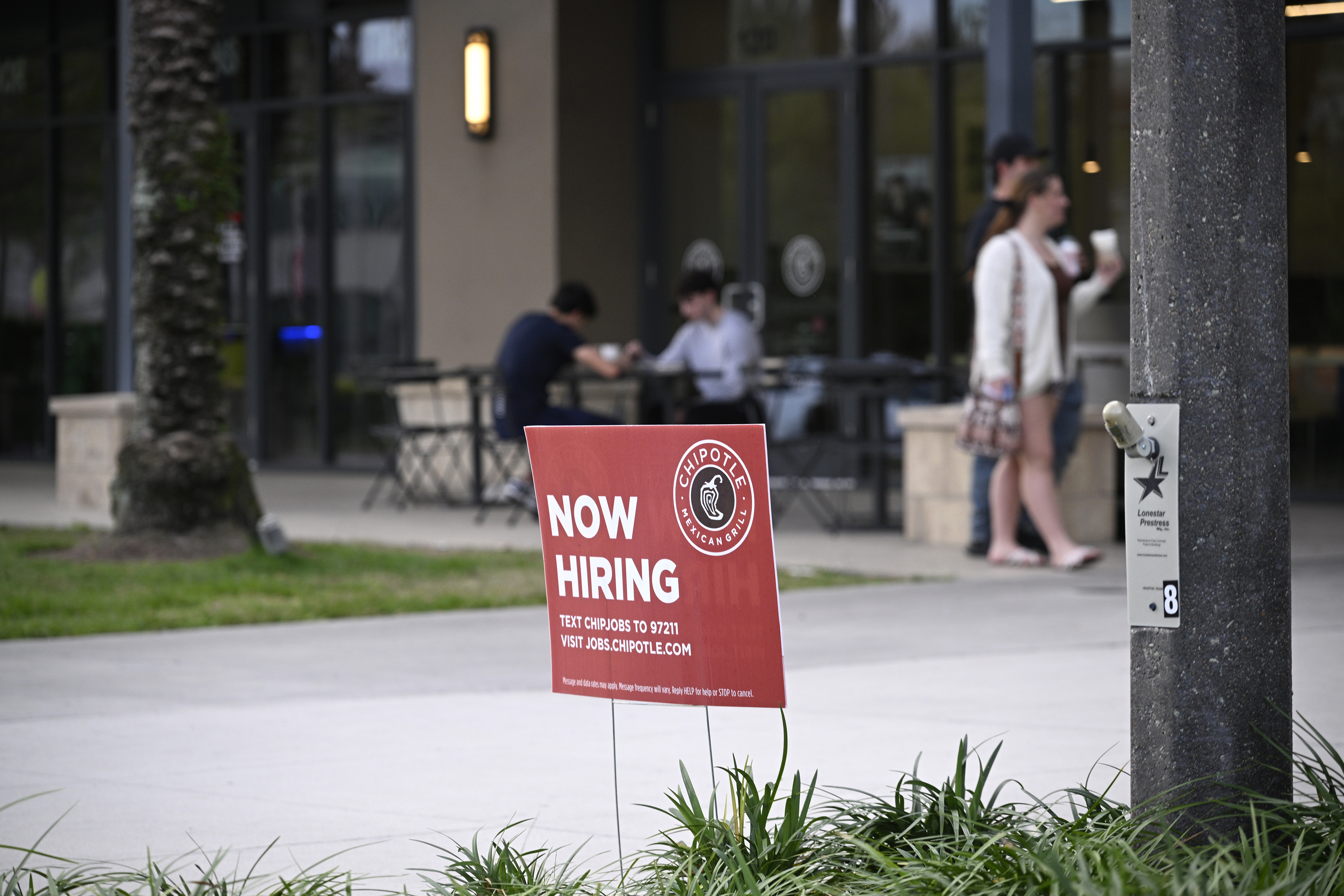 A “Now Hiring” sign advertising job openings is pictured outside a Chipotle restaurant in Windermere, Florida, on March 18.