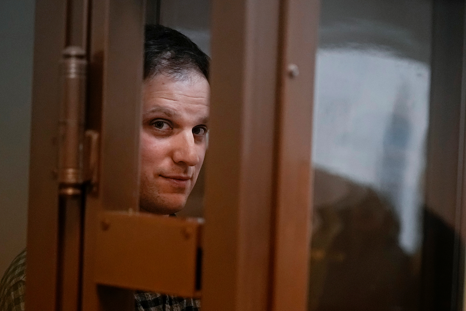Evan Gershkovich stands in a glass cage in a courtroom at the Moscow City Court, in Moscow, Russia, on April 18.