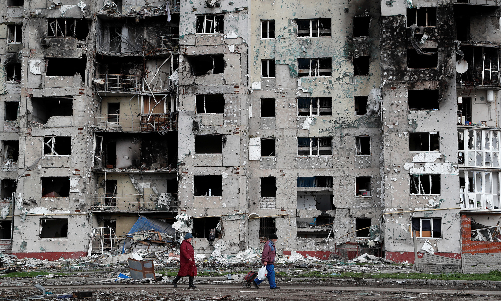 People walk along a street near a residential building in the southern port city of Mariupol, Ukraine, on April 22.