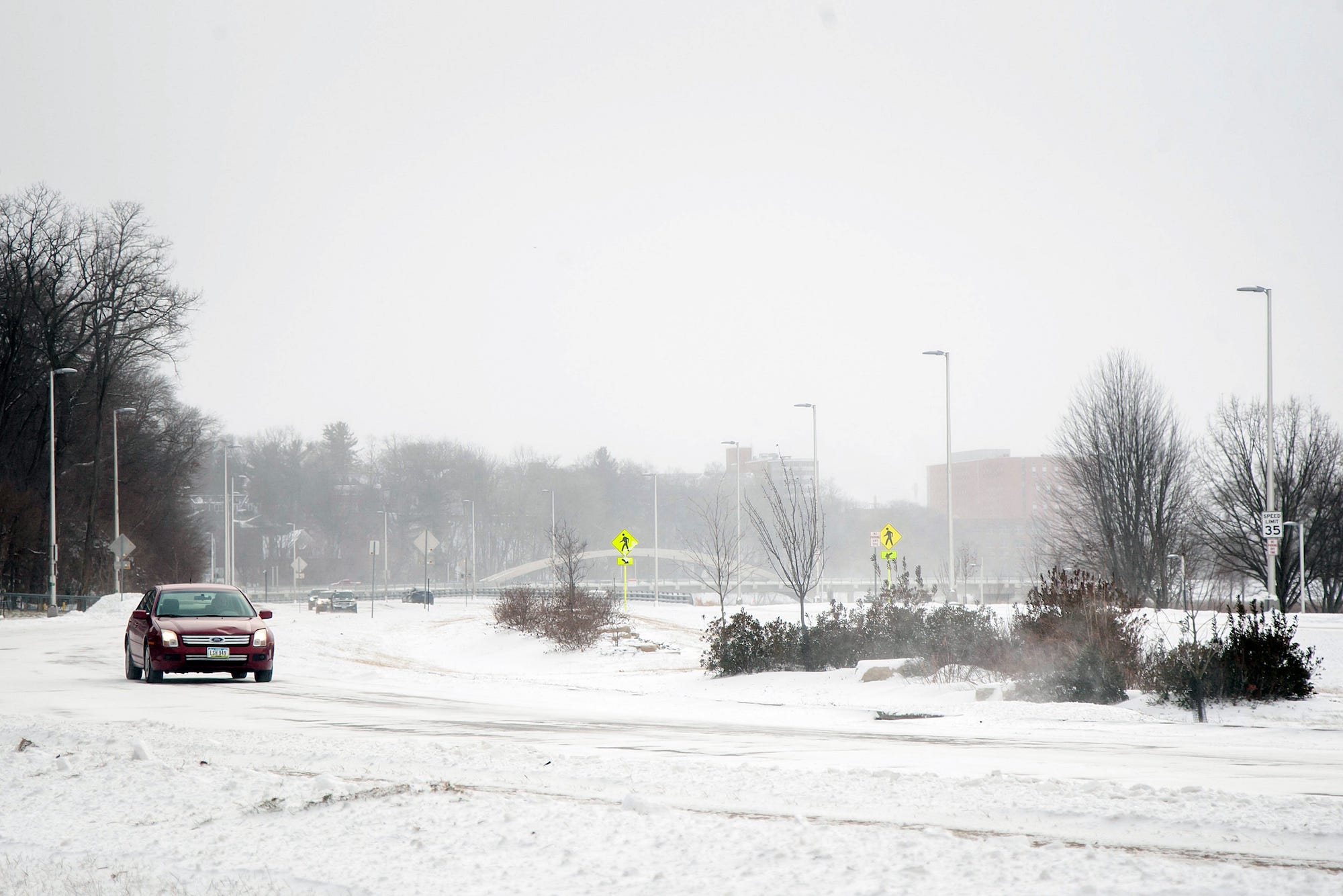 A car drives during a blizzard warning in Iowa on Friday.