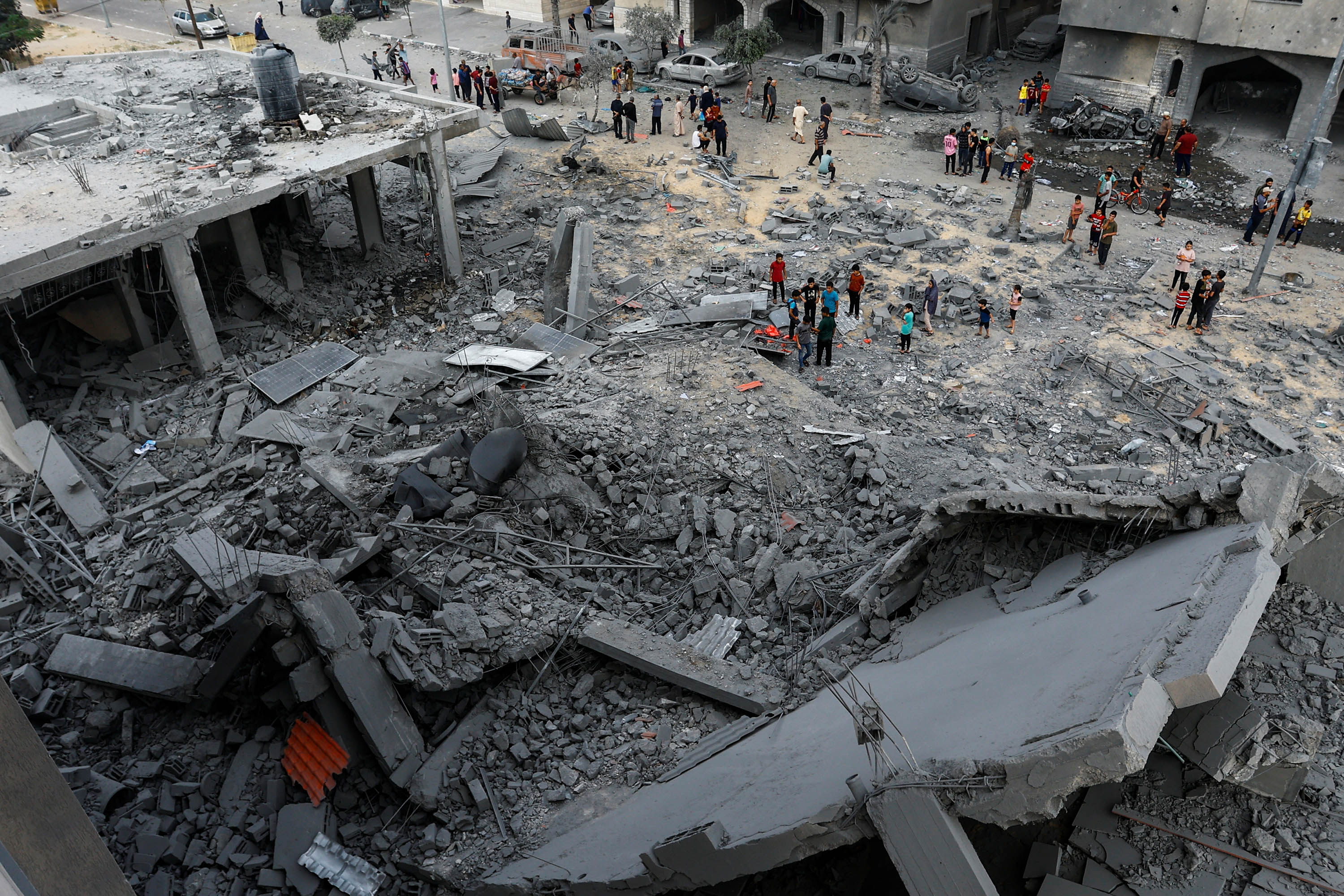 Palestinians gather at the site of Israeli strikes on a house in Khan Younis, Gaza, on Monday, October 23.