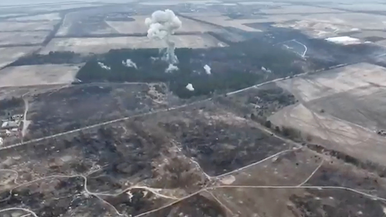 A cloud of smoke rising from a forest is seen in a screenshot from the video.