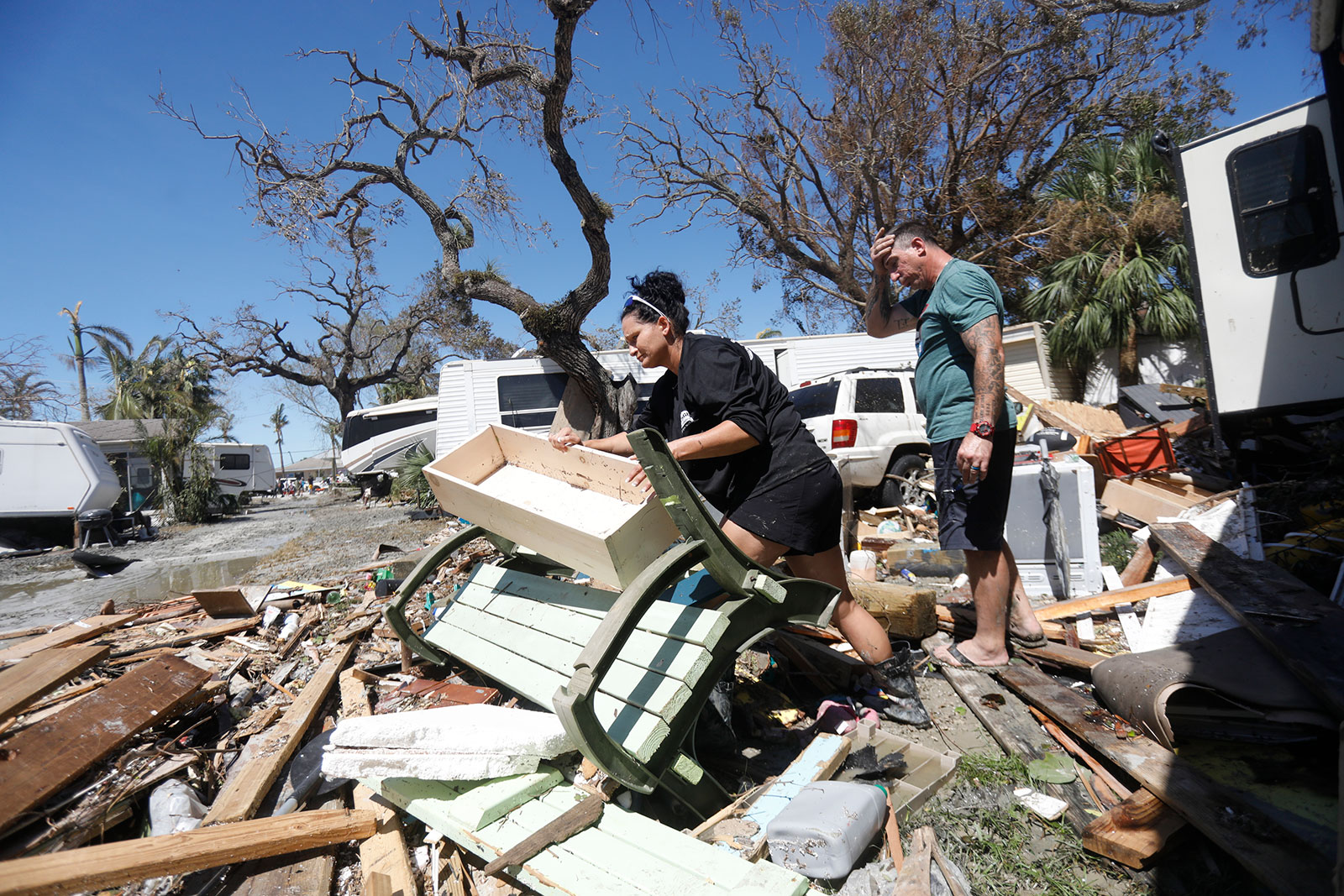 Betsy Hayward and her husband John Riili try to salvage their belongings from their RV mobile home in the Port Carlos Cove community located across from Fort Myers Beach on September 30. 